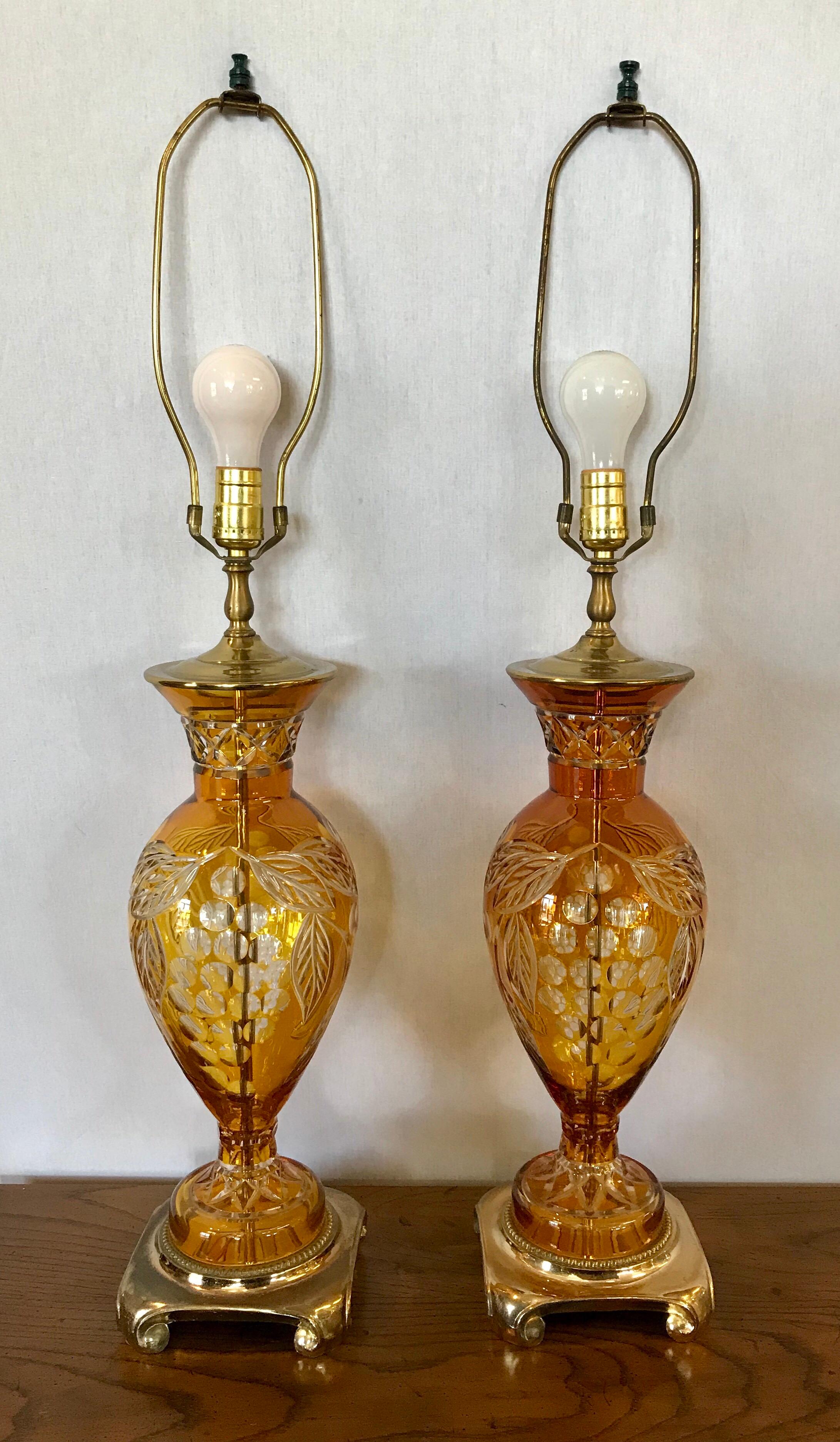 Elegant, Bohemian cut to clear glass table lamps, a matching set. Glass is a vivid amber color and the shades are original, circa 1960s. Wired for USA and in perfect working order with brass bases.