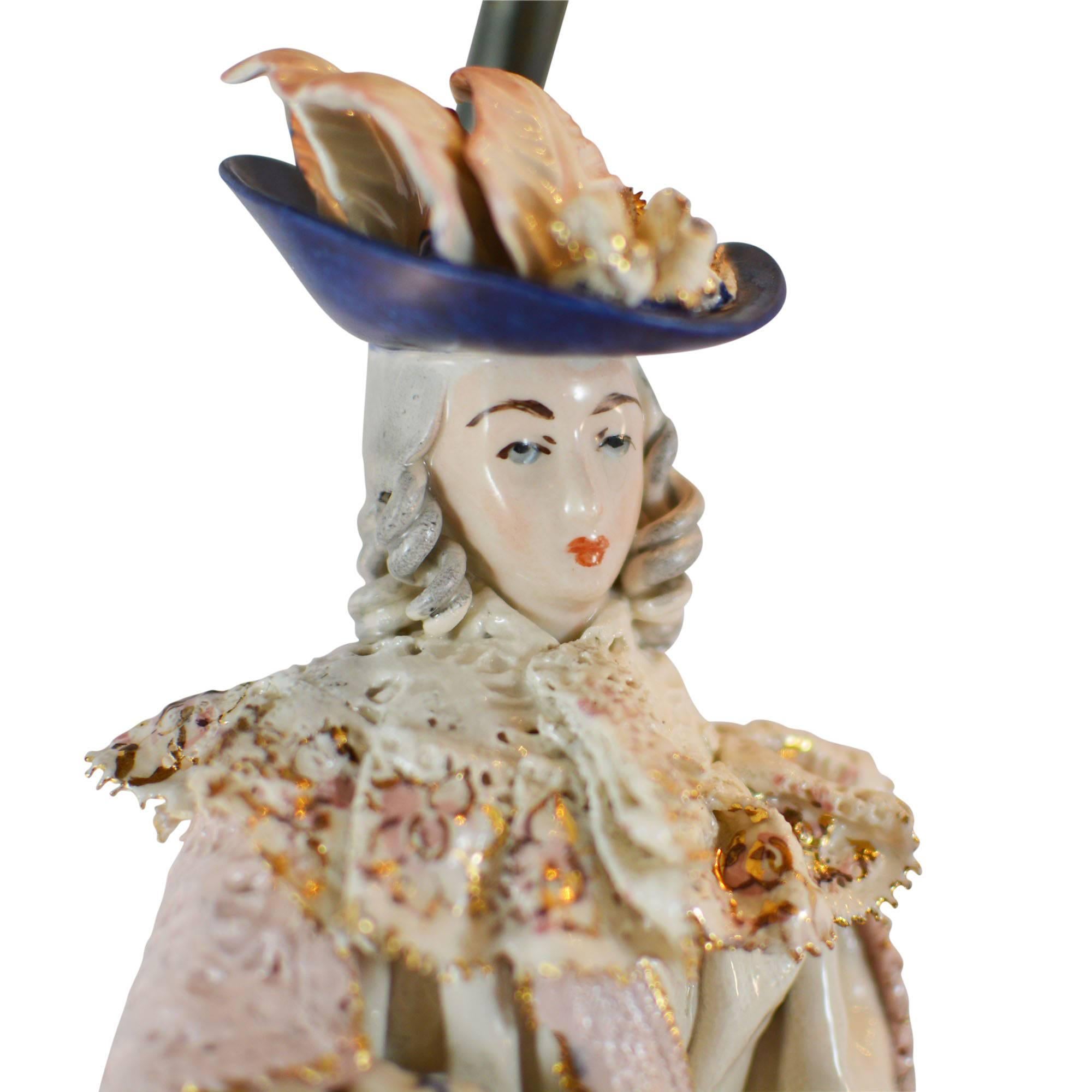 Intricately designed pair of Cordey lamps highlighting a beautiful woman on one and a handsome man on the other. Each are a creamy porcelain featuring hand-painted, radiant gold details. Her dress is an intricate cut lace detail with ruffles and