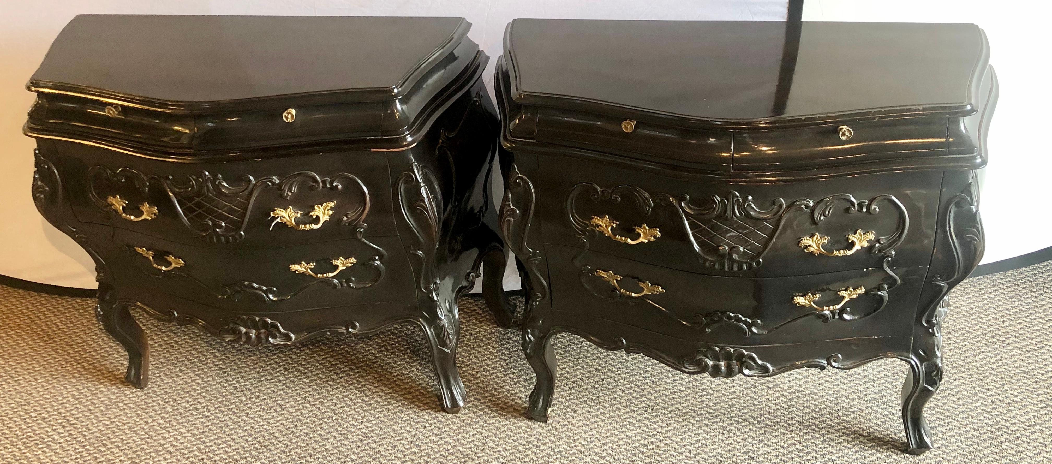 Pair of Bombay ebonized nightstands or end tables. These stunning and finely finished Louis XV style commodes or nightstands have a Bombay form and are carved in an all ebony finish. This pair are sure to make a stunning addition to any Hollywood