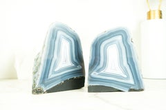 Coppia di piccole geodi di agata blu con retro lucido e paesaggistico.