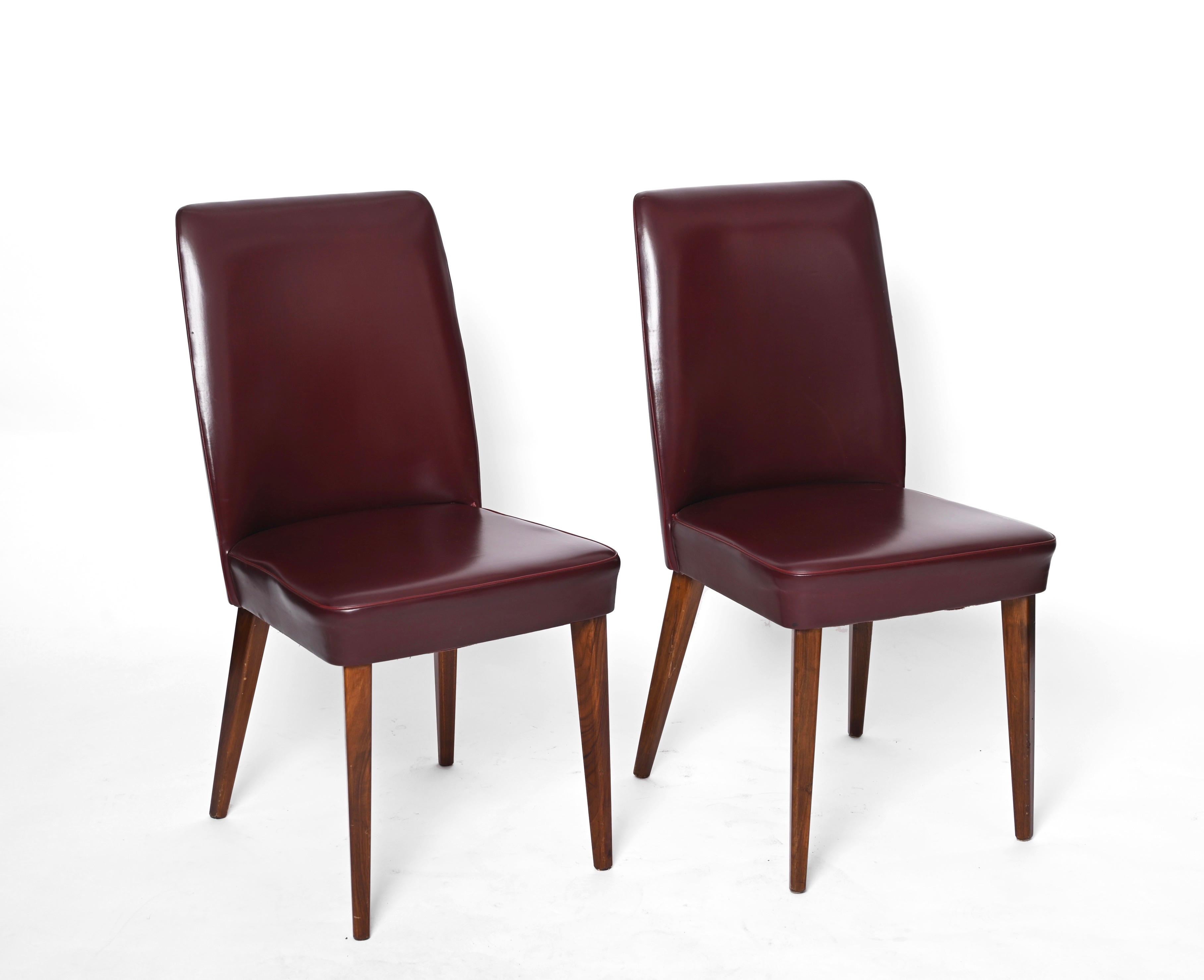 Beautiful pair of sky leather chair by Anonima Castelli Bologna Italy. These beautiful chairs were produced in Italy in the 1950s.

Padded and covered in the original bordeaux leather, the chairs features four legs in dark beechwood that pair
