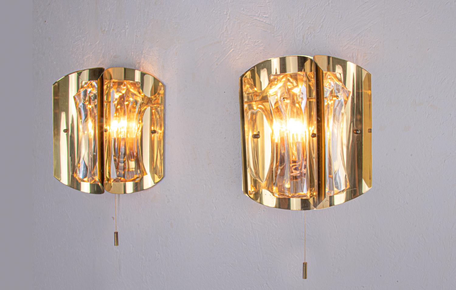 Elegant ensemble de deux appliques murales, chacune avec trois verres en cristal lourd sur une monture en laiton plaqué or. Usage intensif. Gemme de l'époque. Difficile à trouver de nos jours. Avec ces luminaires, vous pouvez faire une déclaration