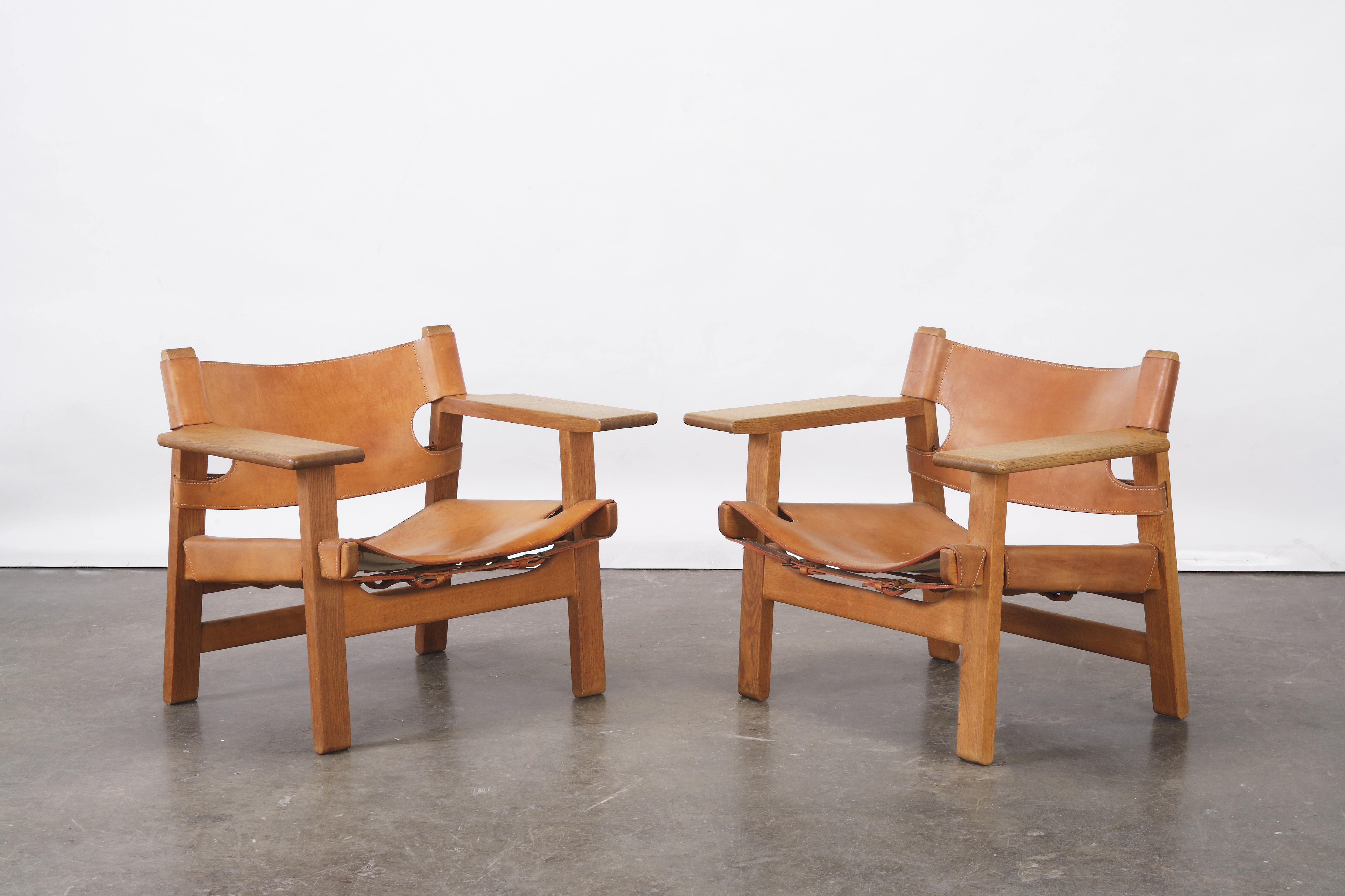 A wonderful pair of early Spanish chairs, in solid oak and patinated cognac leather, designed by Børge Mogensen for Fredericia Stolefabrik, Denmark, in 1958. In very good original condition, a beautiful even patina, a couple of minor spots to the