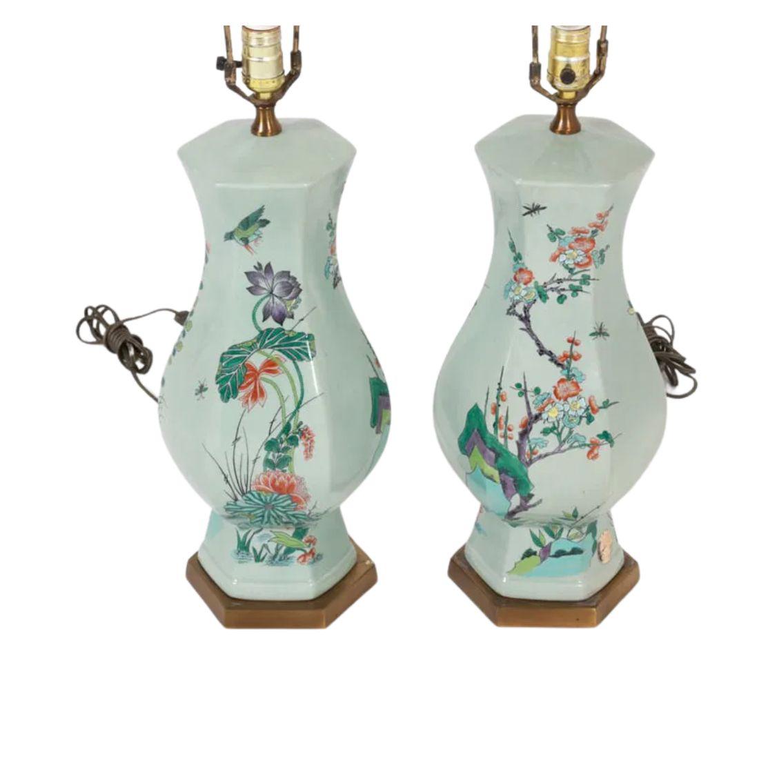 Cette paire de lampes de table en céramique céladon peinte présente une forme hexagonale frappante, apportant une touche contemporaine au design asiatique traditionnel. La douce glaçure vert pâle de la céramique est complétée par un motif botanique