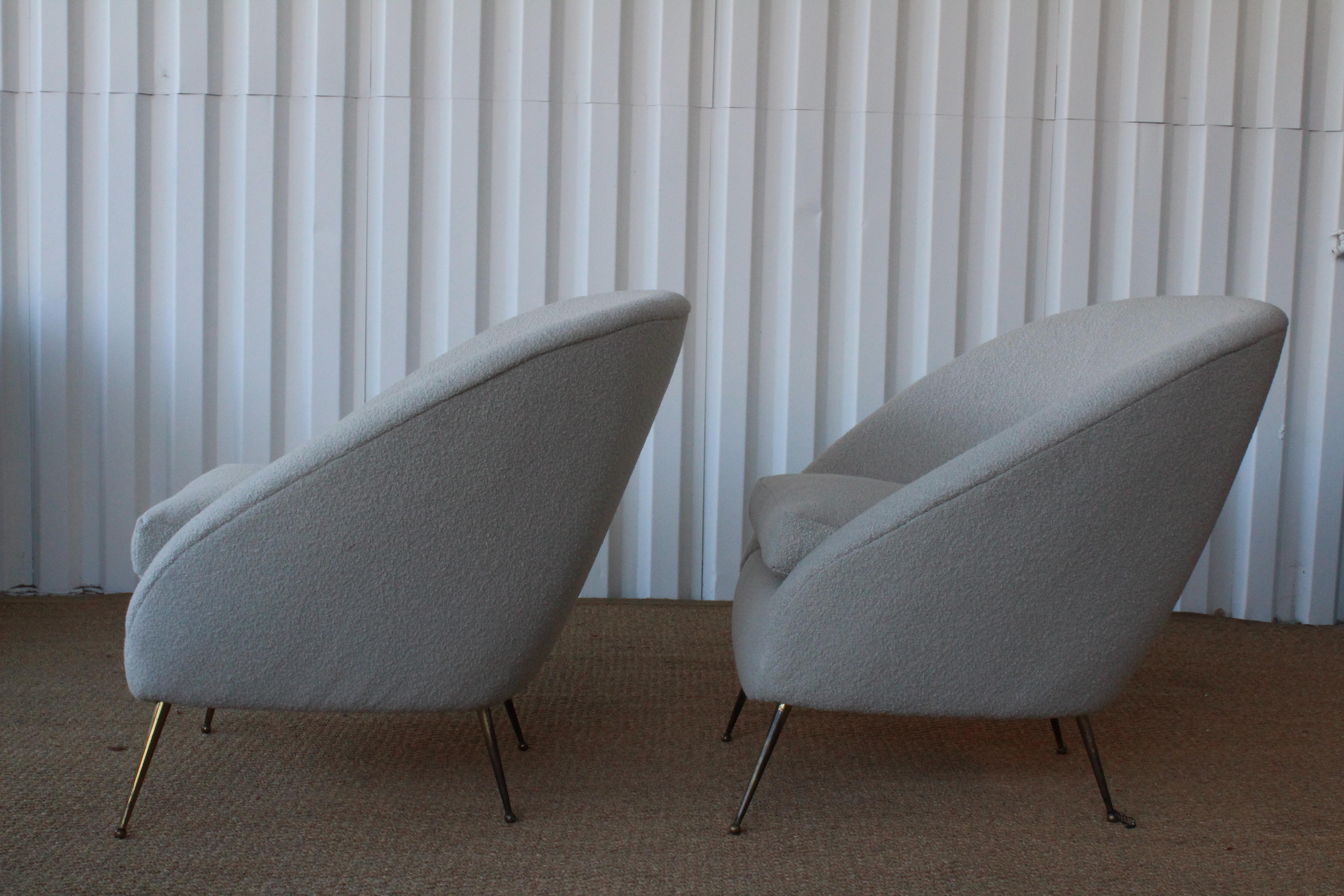 Pair of 1950s Italian lounge chairs with brass legs, fully restored and reupholstered in a wool blend bouclé fabric. Wonderful patina to the brass legs.