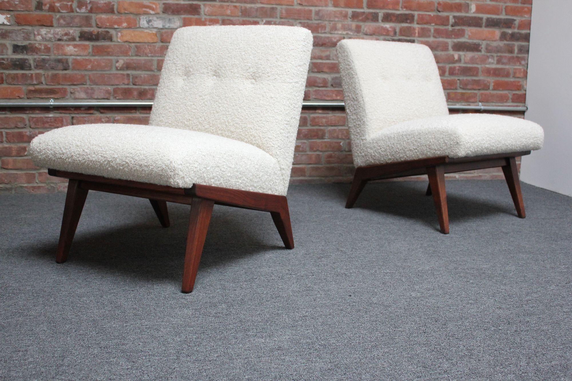 Jens Risom for H.G. Knoll Associates armless slipper chairs composed of upholstered seats supported by walnut bases (first appearing in the 1942 Knoll catalog). 
There is a slight design disparity between the two chairs - the wood joinery in the