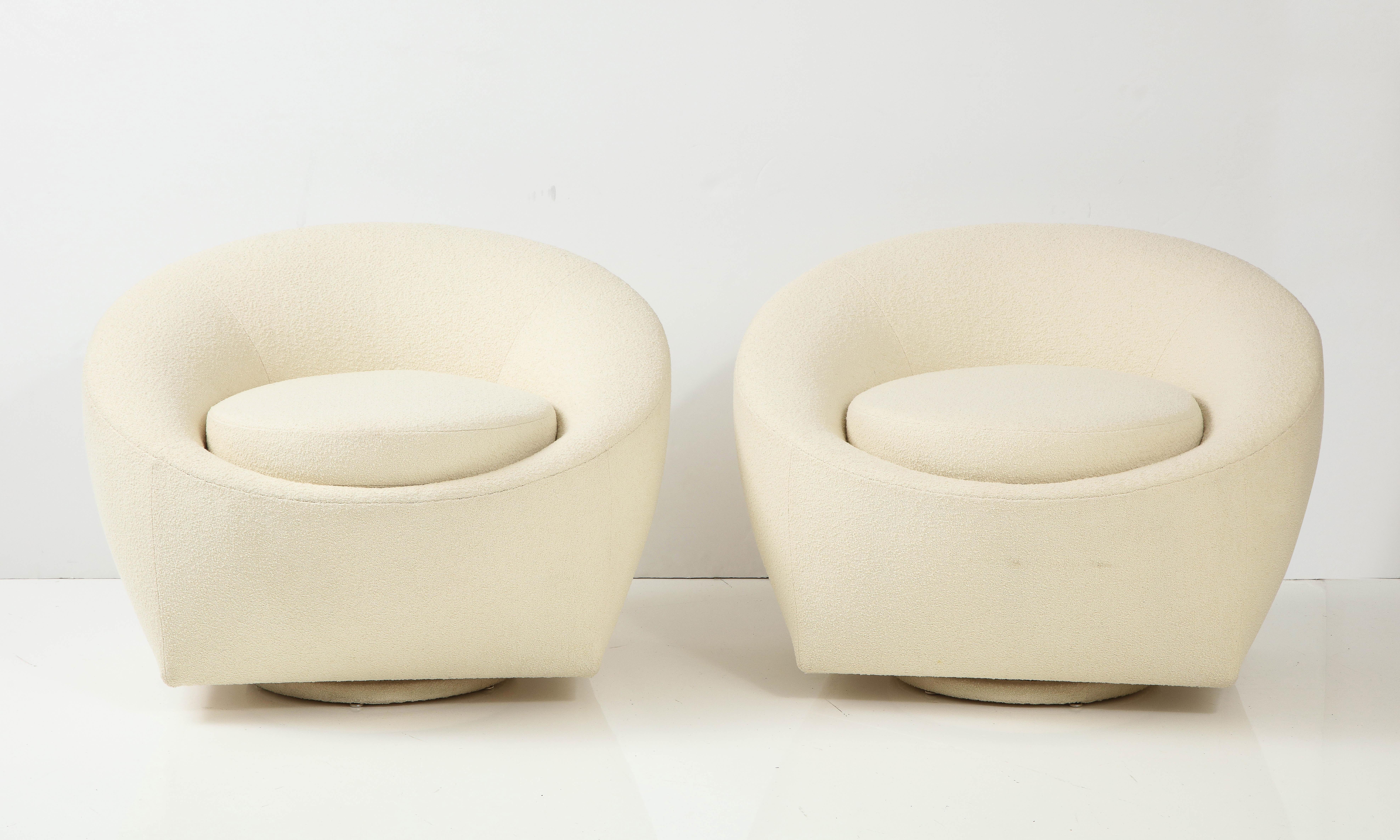 Pair of Mid-Century Modern swivel chairs that have been Newly Reupholstered 
In soft Ivory Knoll Boucle fabric. The bases of the chairs are also reupholstered in the 
same fabric.

