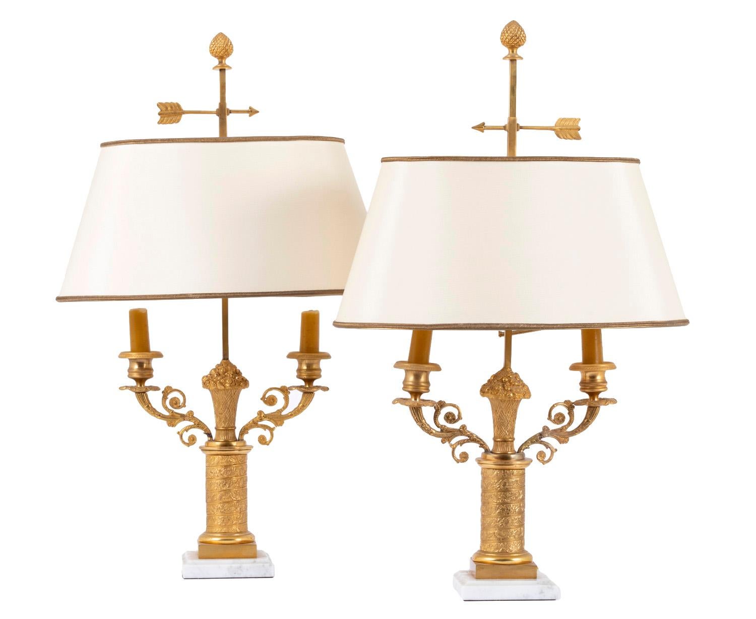 Pair of bouillotte lamps Restoration style in gilt bronze with two light sources. White veined Carrara marble square base topped with gilt and chiseled bronze structure. Gilt base topped with toric molding. Lamp shaft in column for is entirely