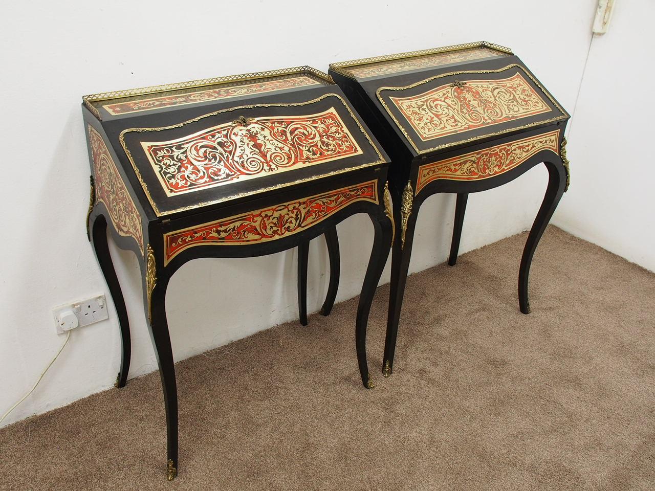 Matched pair of freestanding Boulle bureau de dame, circa 1860. The ebonized tops have a fretted brass three-quarter gallery and finely engraved brass and red tortoiseshell inlay. It has a shaped flap with ormolu rim which opens to reveal an inlaid