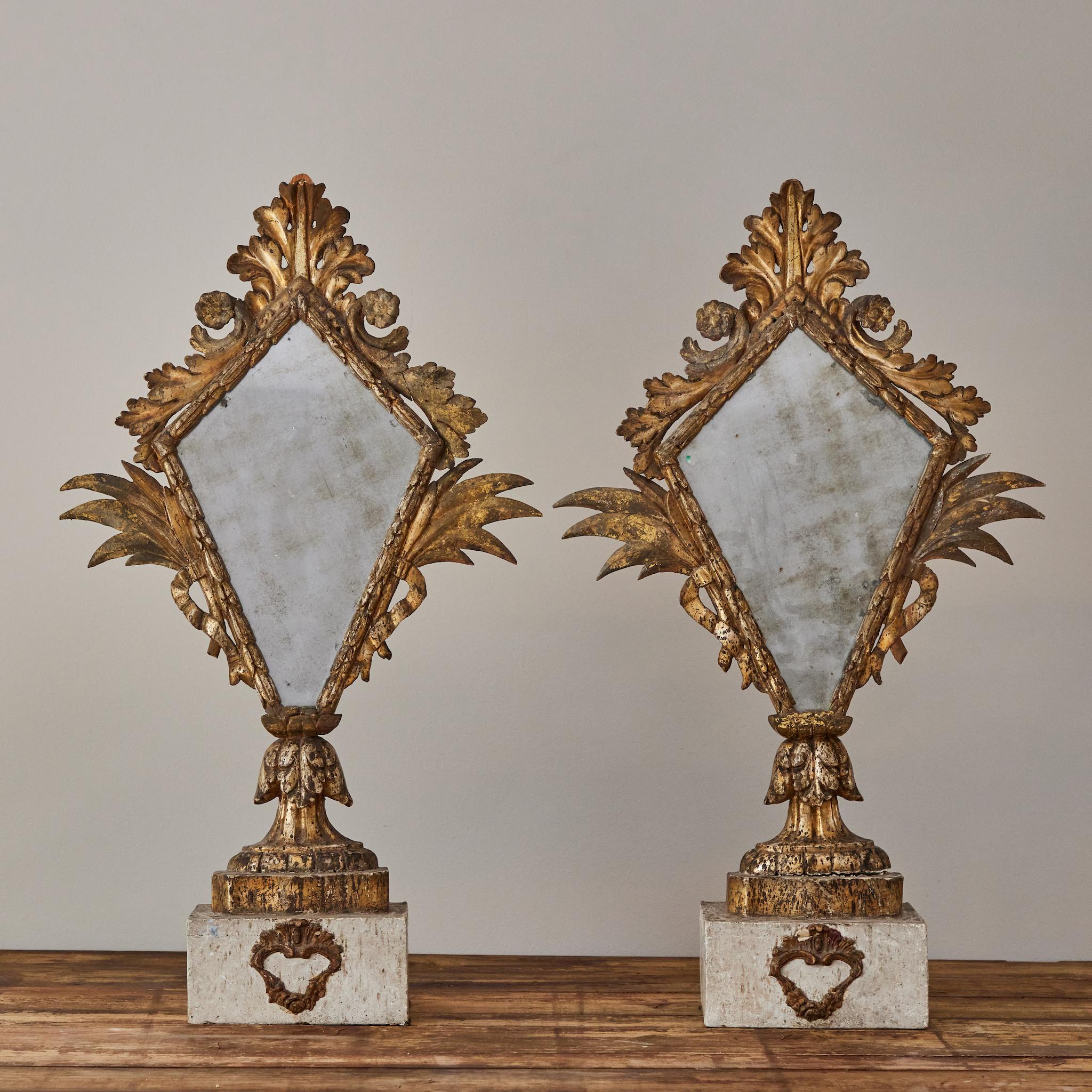 Pair of French Empire style painted and gilt wood brackets or sconces with original mirrors. The glass is smoky and beautifully mottled, the surrounding decoration in wonderful condition. A sumptuous, romantic addition to any space.
