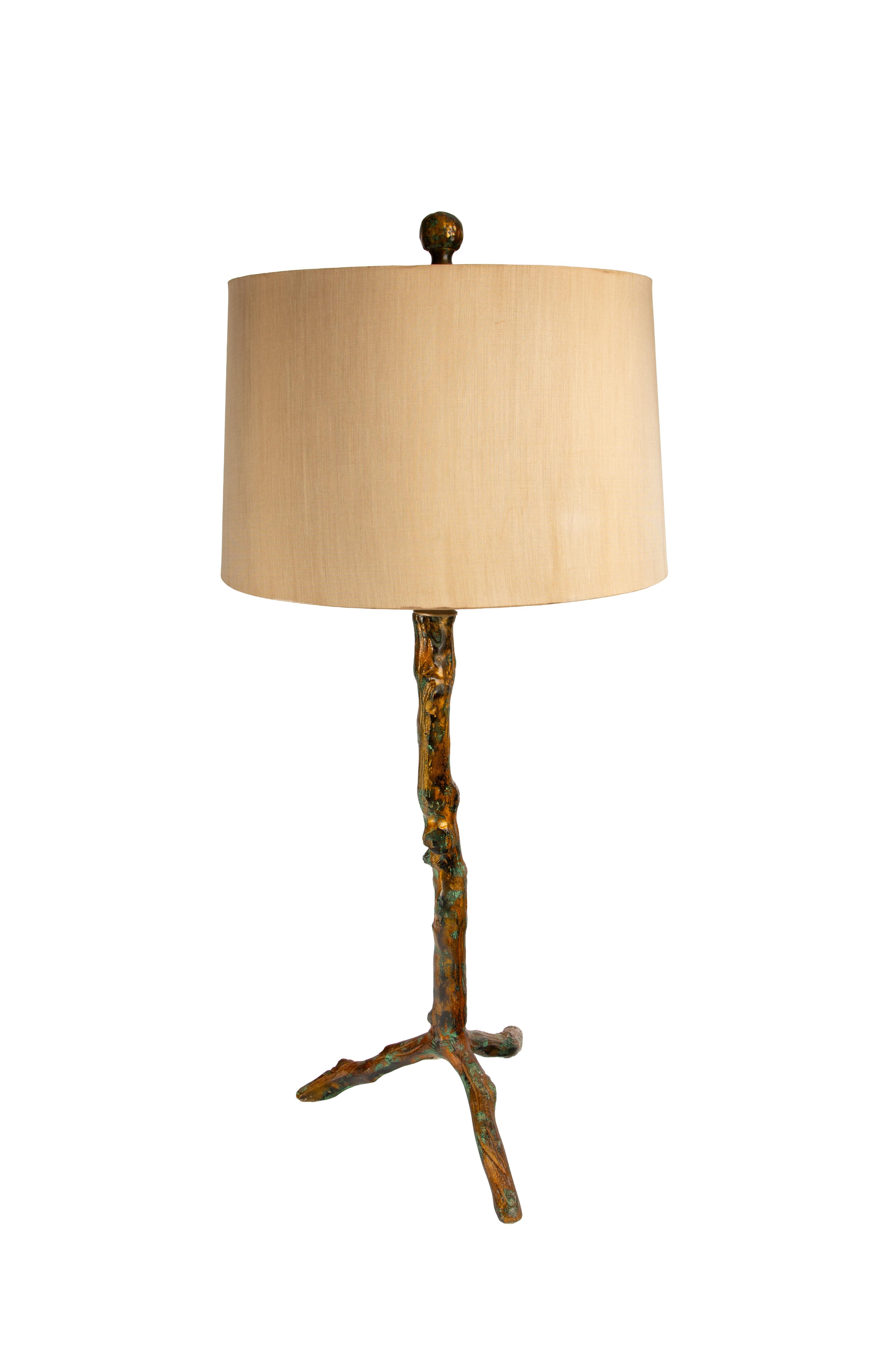 This distinctive pair of table lamps features bases sculpted to resemble natural tree branches. Cast in metal and finished with a warm, hand-applied gold patina, the surface is accented with faux verdigris moss, creating a richly textured and