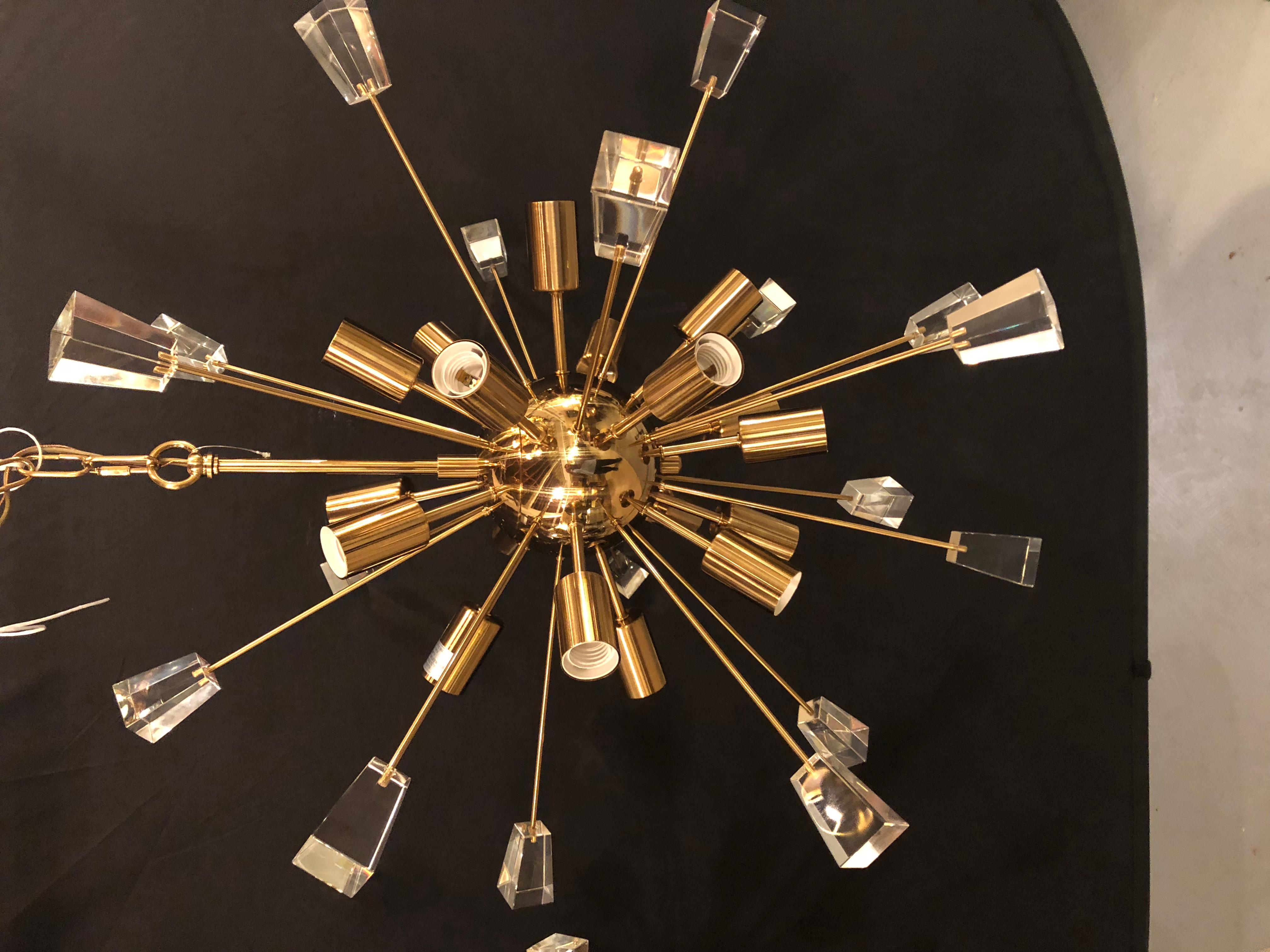 A pair of brass 18-light Sputnik chandeliers in the Mid-Century Modern style. We have two pair of these stunning chandeliers one is larger (34 inch diameter) than the pair in this listing. This pair come with a matching canopy and a chain that is