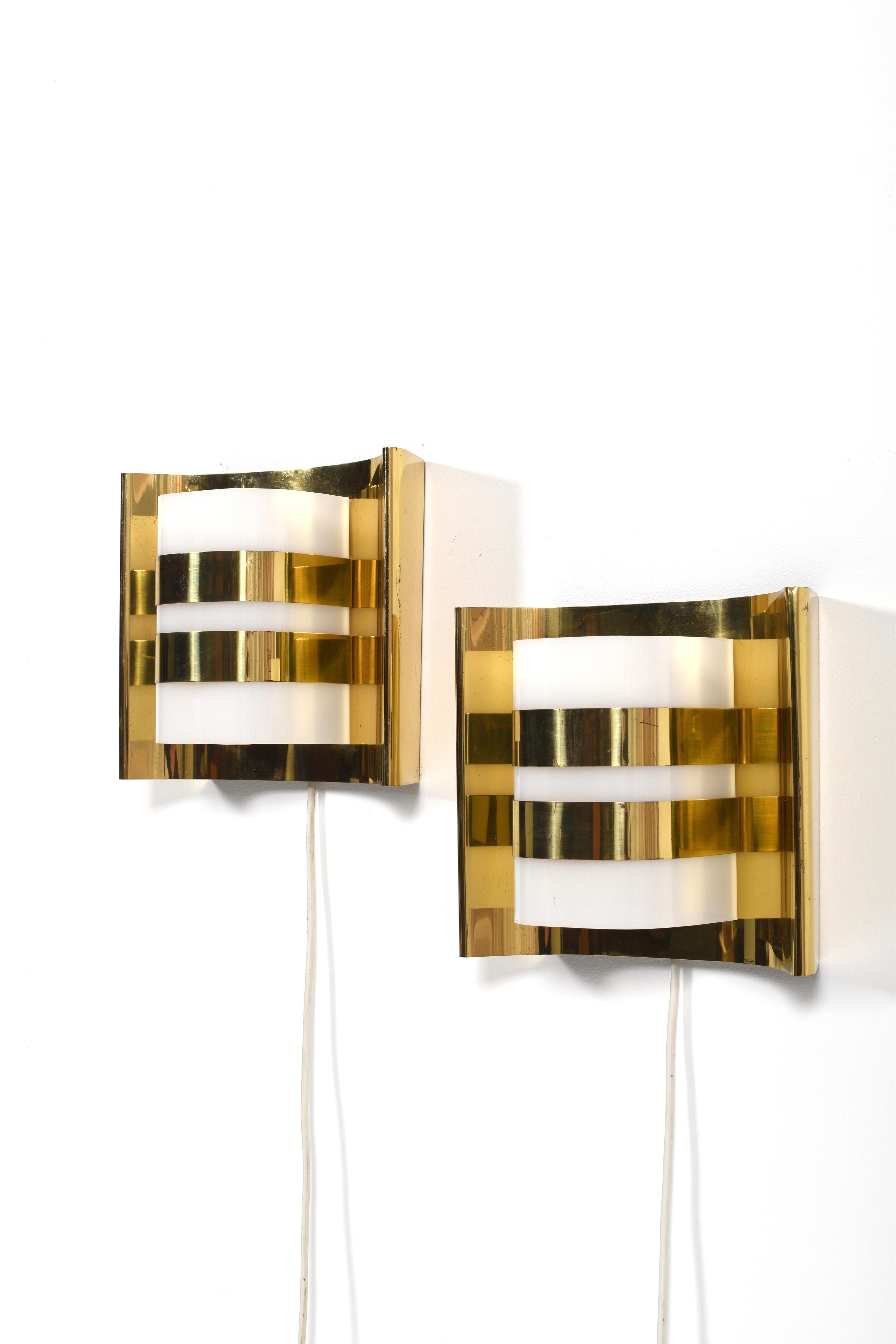 Coppia di lampade da parete disegnate da Hans-Agne Jakobsson per Hans-Agne Jakobsson AB, Markaryd, Svezia, anni '60. Modello V334/1, queste applique scultoree sono caratterizzate da paralumi in metallo ottonato elegantemente curvati in contrasto con