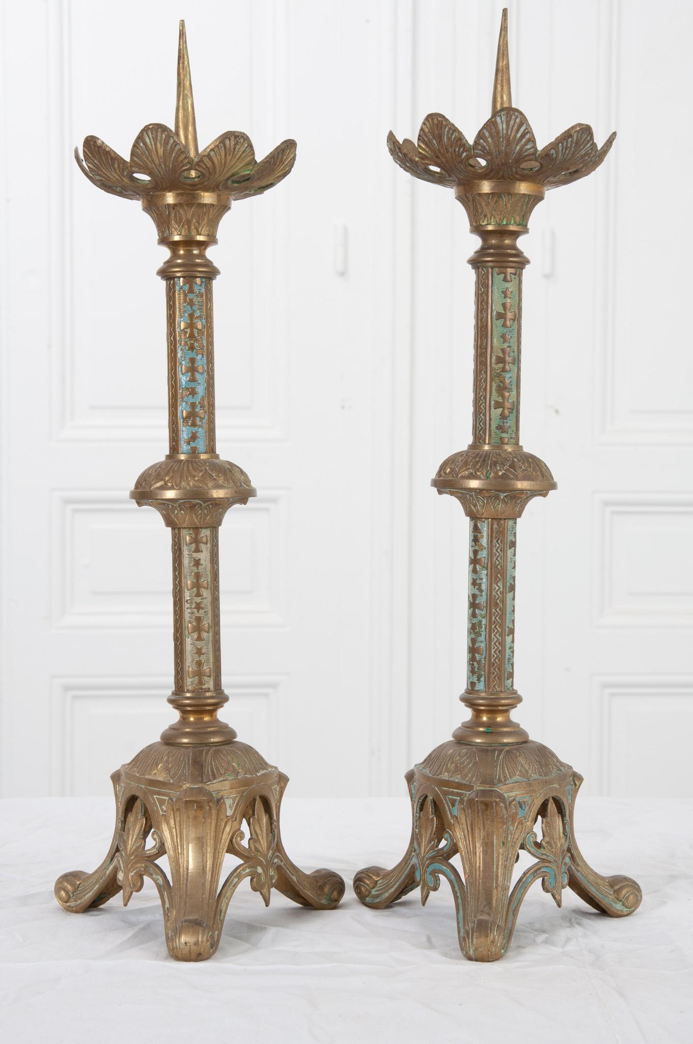 This stunning pair of candlesticks were made in 19th century France and most likely used for religious purposes for many years. Fantastic details throughout include stunning pierced brass tripod feet, crosses and stars, and detailed leaves. Hints of