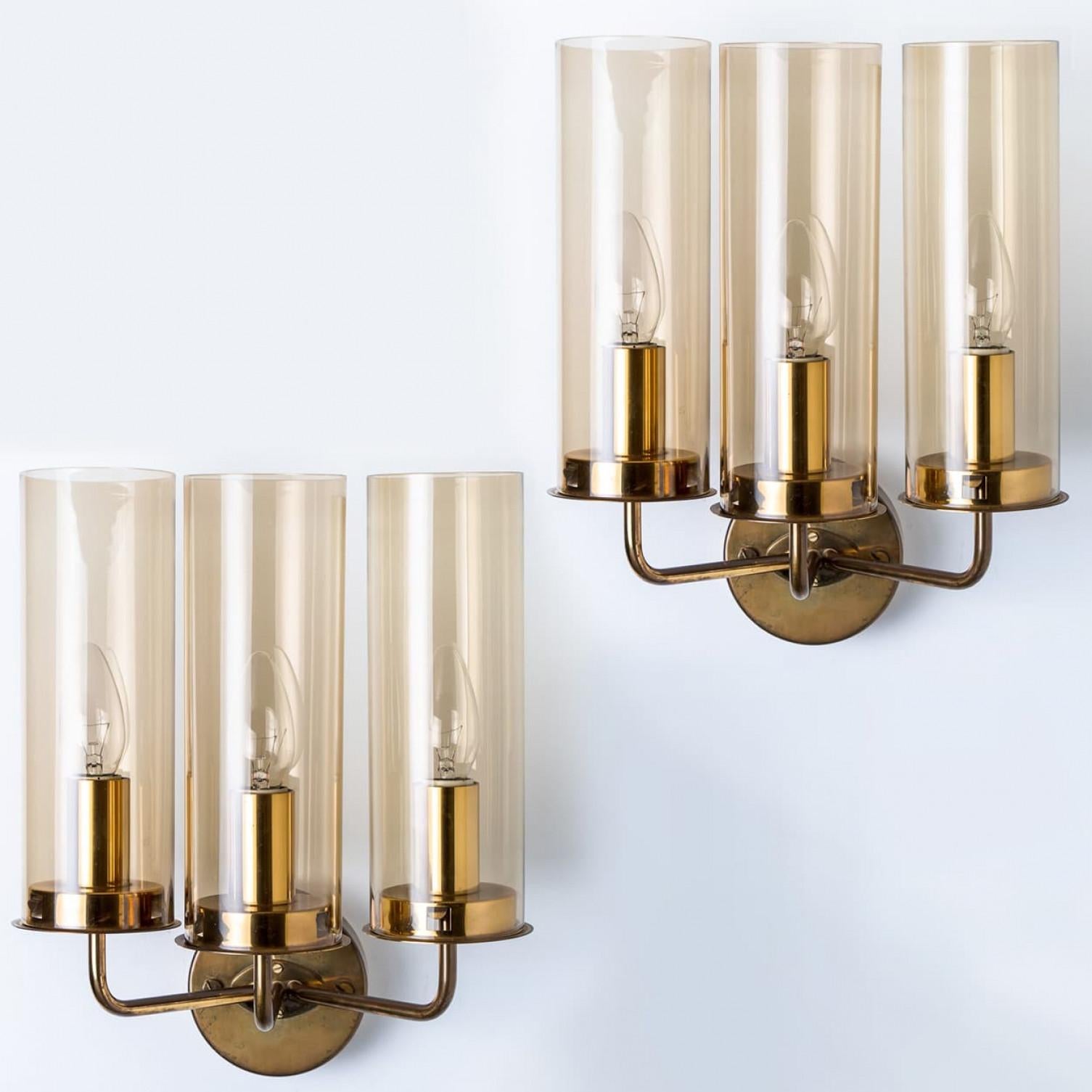 These stunning brass wall lights with amber glass are produced in the 1960s by Jakobsson. Design executed with a taste for excellence in craftsmanship.

Well-wired, in full working order and ready to use. Each fixture requires three E14 standard