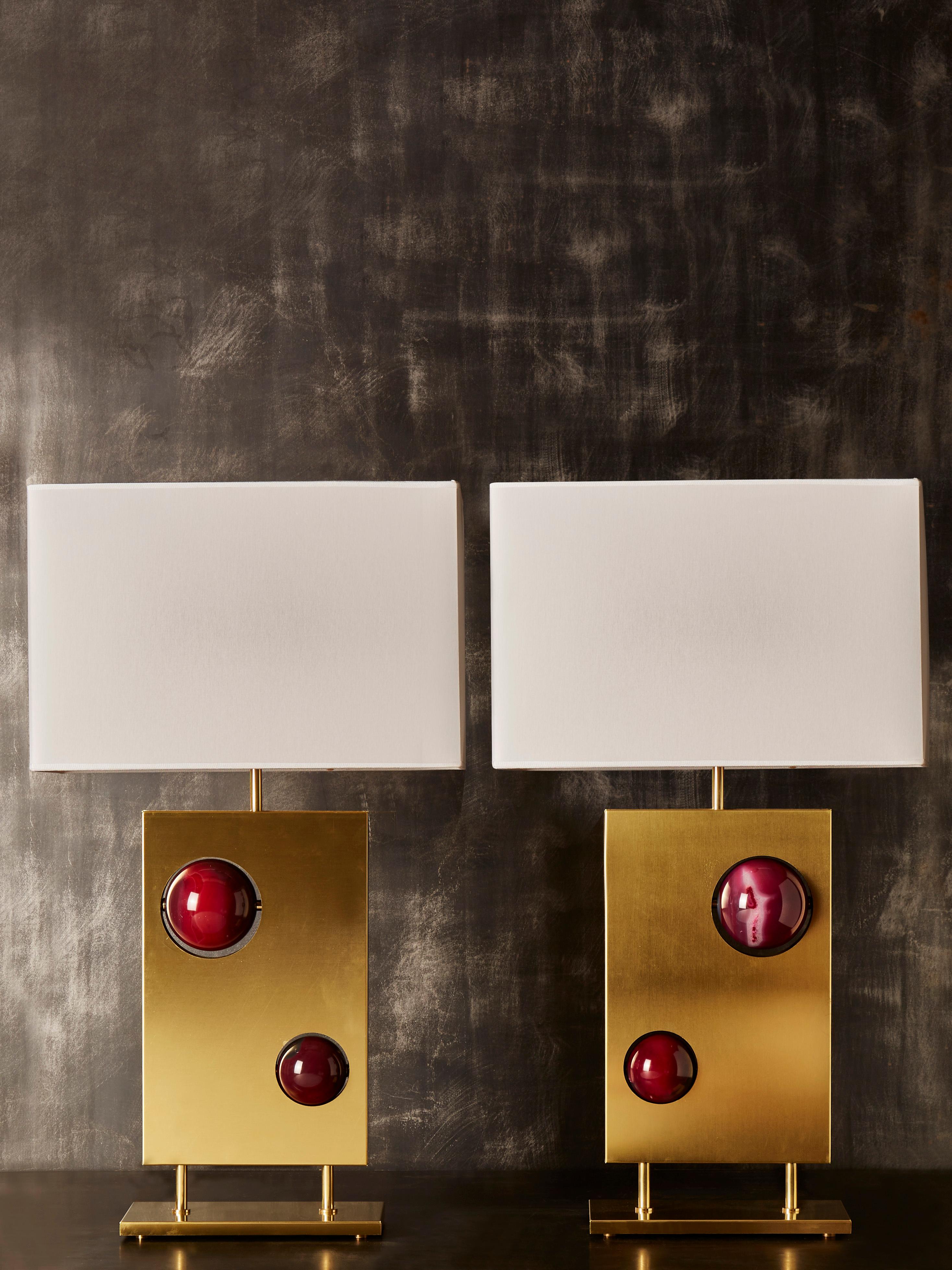 Pair of nice lamps made of a rectangular black metal body, covered on both side by brass plate. Each lamp has two sculpted sphere of pink agates visible from both sides.