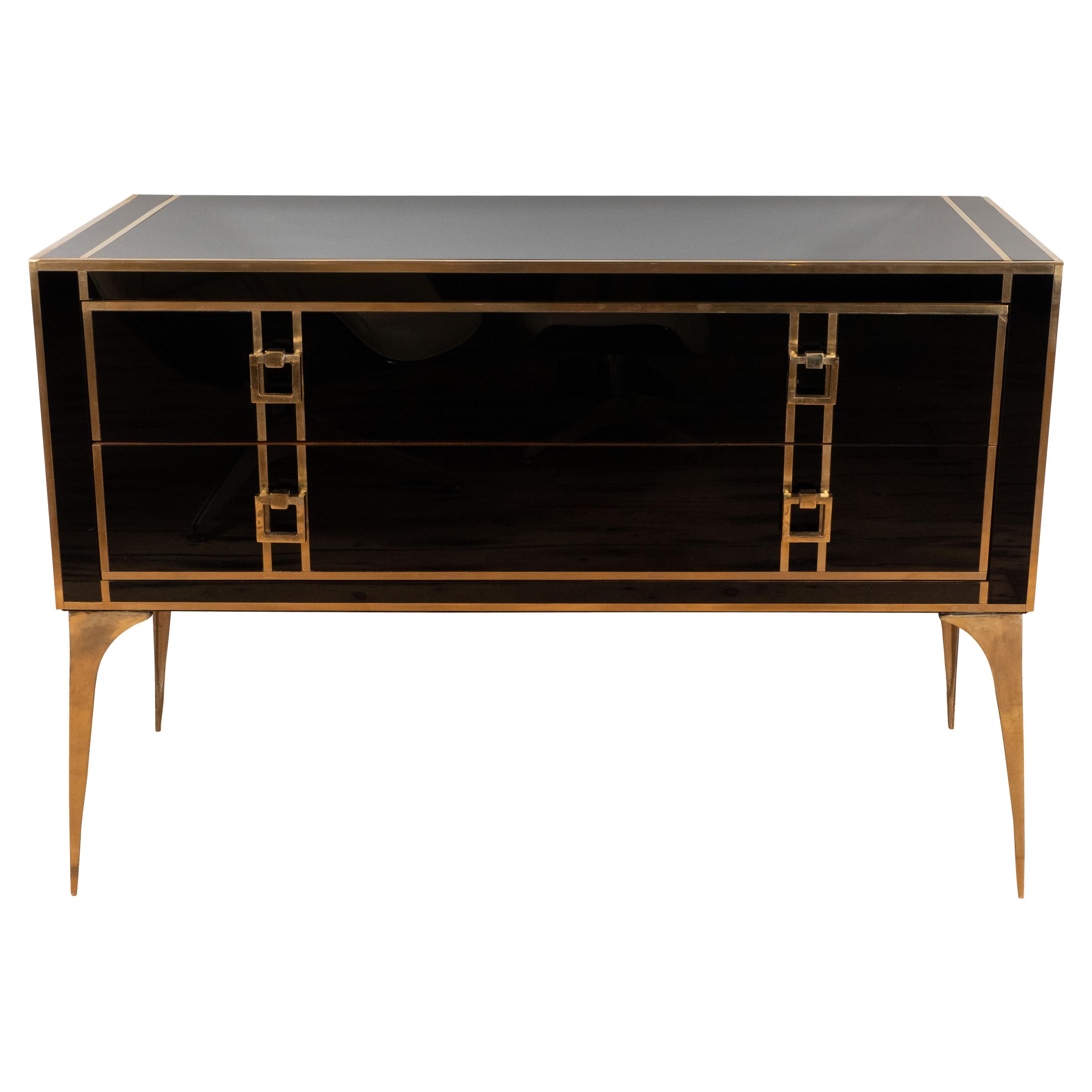 One of a kind pair of black glass and brass chest of drawers or commodes handmade in Venice, Italy by a master artisan and artist. Wooden frame is covered in handcrafted Black tinted glass panels with brass inlays. Elegant solid brass square pulls
