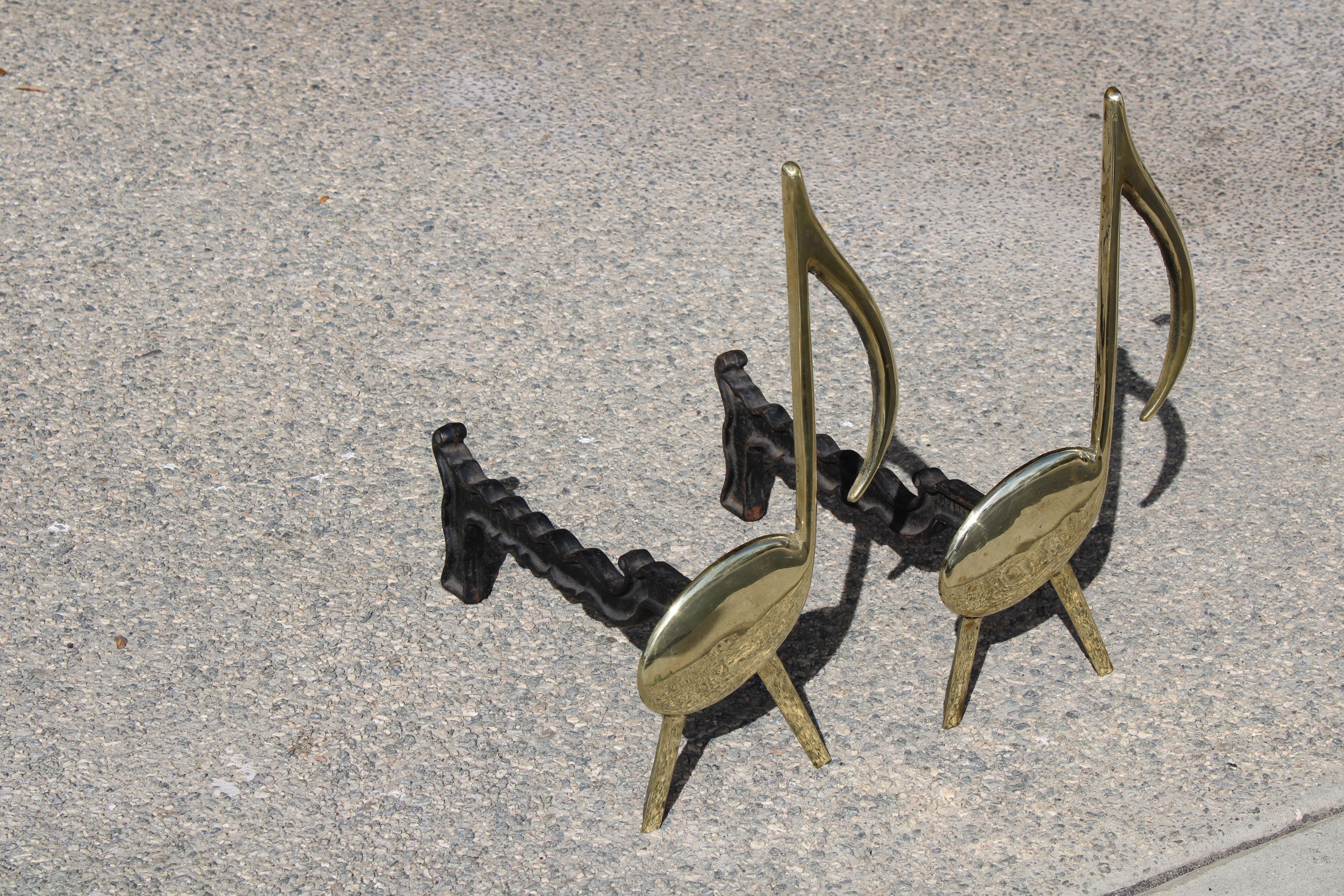 Pair of brass and cast iron musical note andirons engraved Tenn. Chrome Plate Co. Nashville. Andirons Measure 8.25