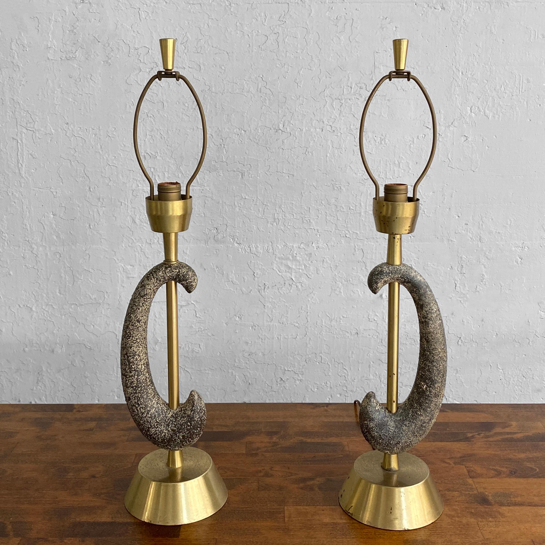 Interesting pair of mid century modern, table lamps by Kelby feature brass bases, stems and original finials with intersecting, black and white, course-graned, ceramic arcs.