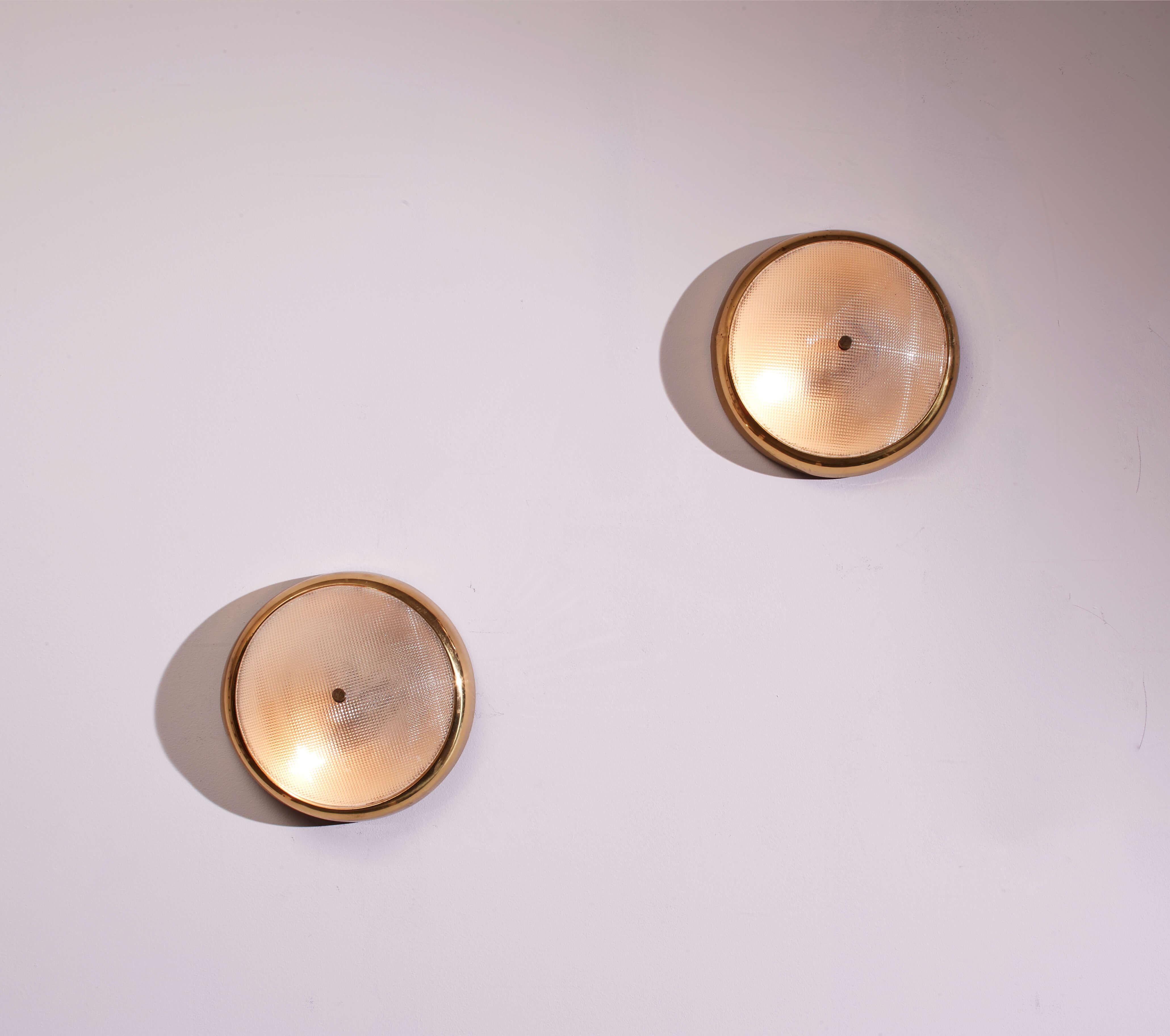 Une belle paire de plafonniers des années 1950, de fabrication italienne, avec du verre rainuré et du laiton.

Chaque lampe est dotée d'une base en laiton poli qui maintient solidement un diffuseur en verre rainuré satiné. La surface du verre est