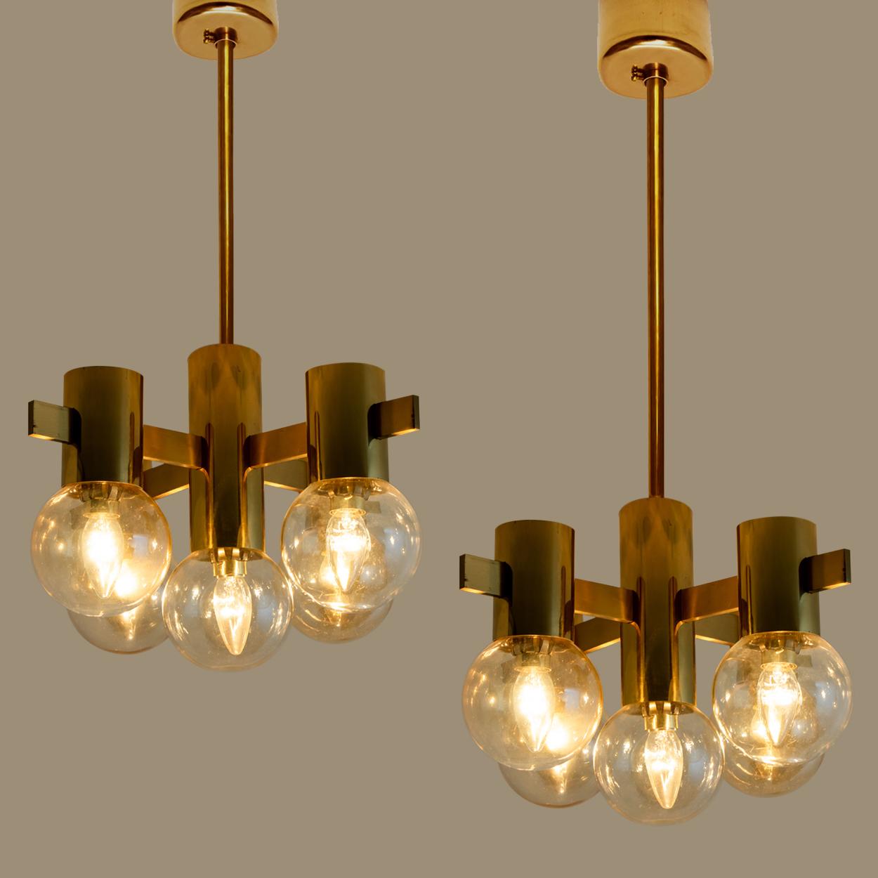 This stunning pair of large brass light fixtures with smoked glass bowls and gold-plated fittings was produced in the 1970s in the style of Hans-Agne Jakobsson. Illuminates beautifully.

Size of the chandelier:
D 18.1