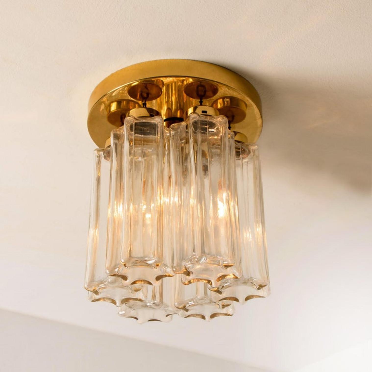Ogni singolo paralume in vetro è a forma di colonna con una stella a sei lati alla base, tutti della stessa dimensione. Insieme, queste forme scultoree aggiungono profondità e riflessione. Attualmente è dotato di lampadine trasparenti, ma può