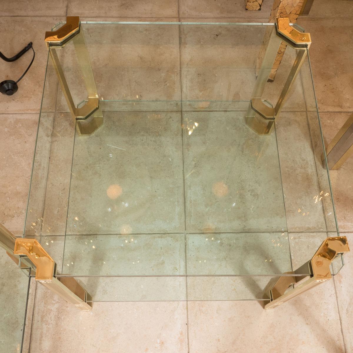 Paire de tables d'appoint carrées à deux niveaux en laiton et verre avec détails décoratifs.

Dimensions : 24.5