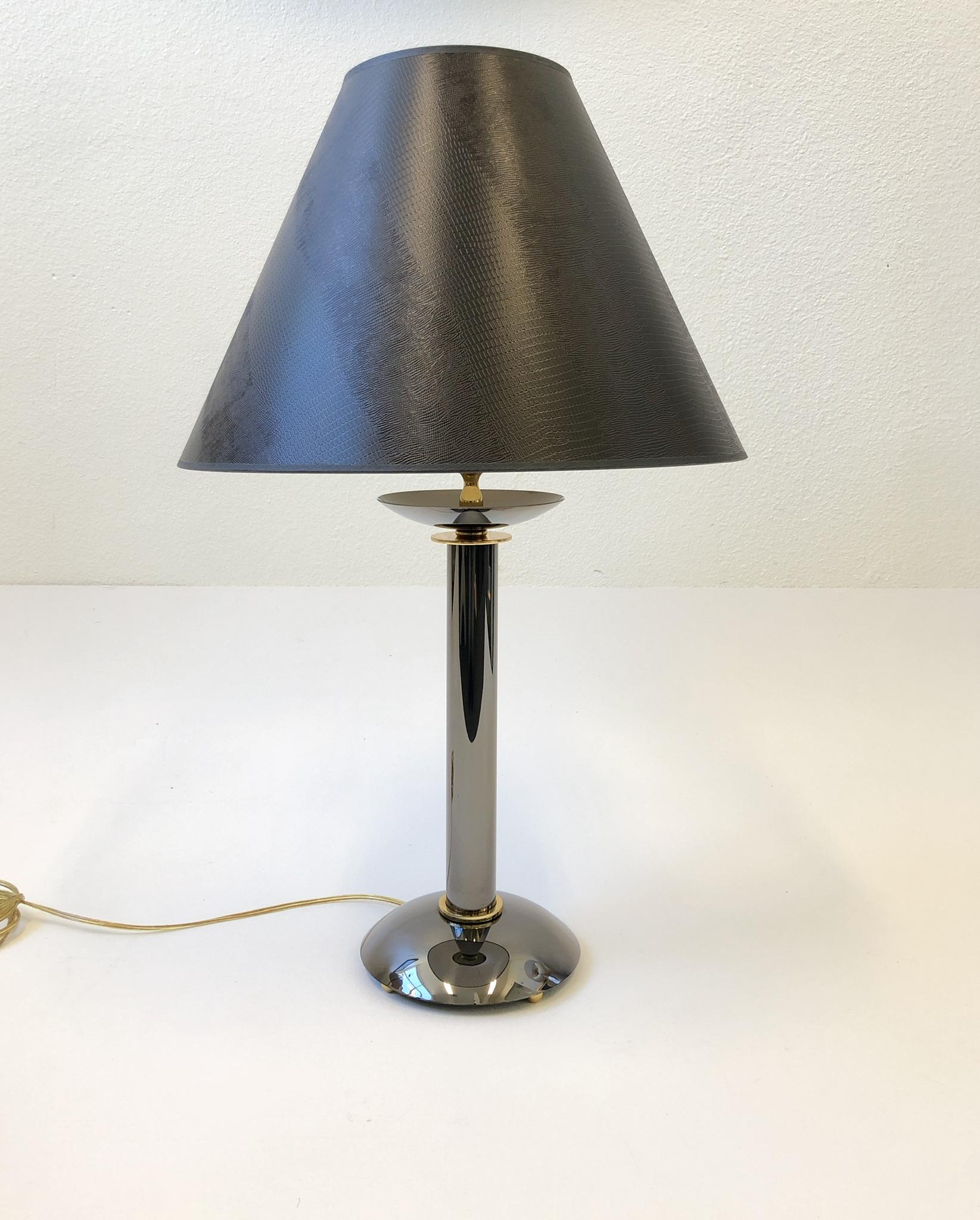 A rare pair of gunmetal and brass table lamps design by Karl Pringer in the 1980s. It’s rare to find this as lamps, they are usually candlesticks. They have been newly rewired with new hardware and new dark brown faux lizard skin lamp