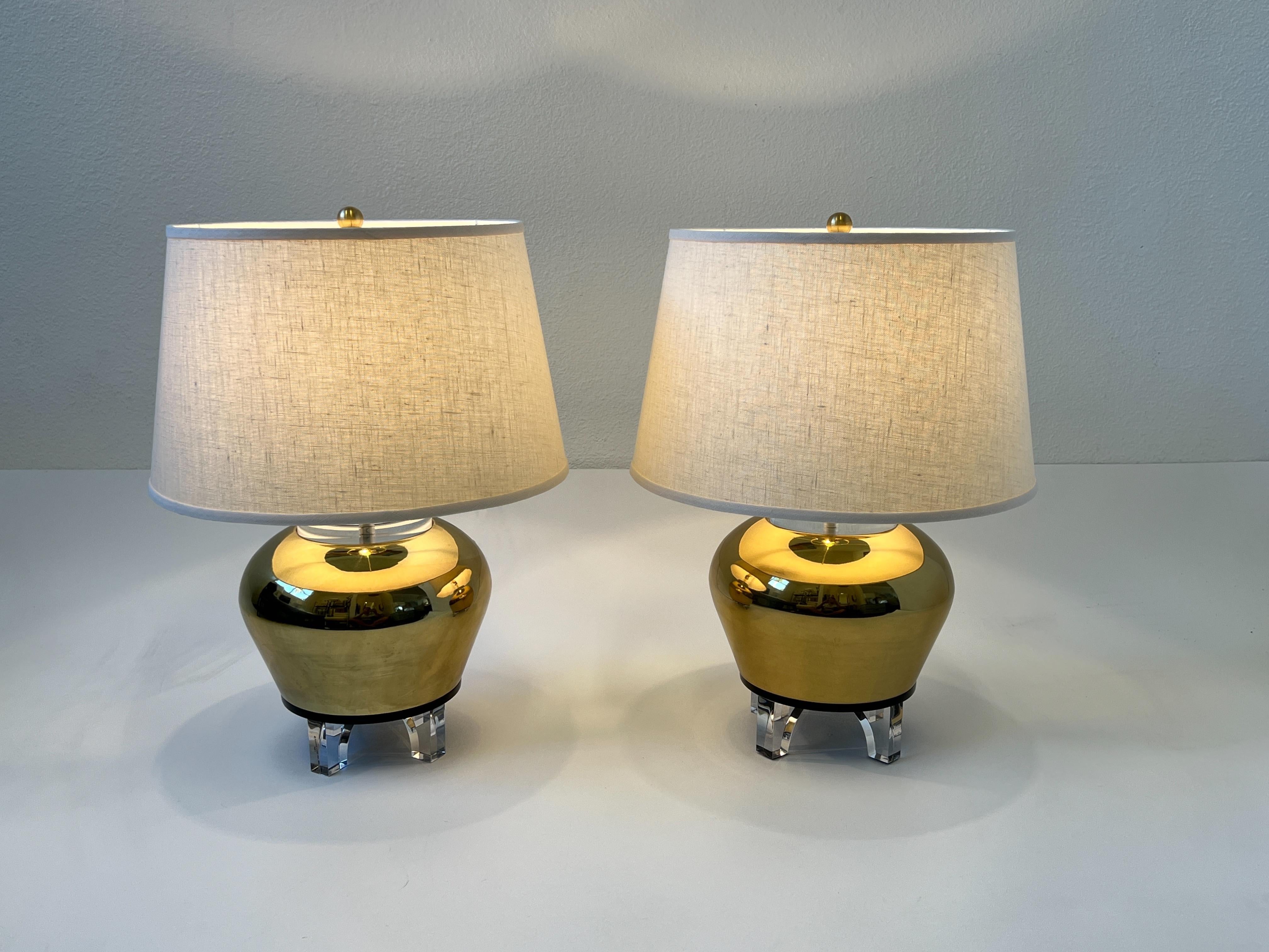 1983 Clear, black lucite and polish brass urn table lamps by Bauer Lamp Company. 
Newly rewired with new brass hardware and new vanilla linen shades. 

Measurements: 16” Diameter, 21.5” High.