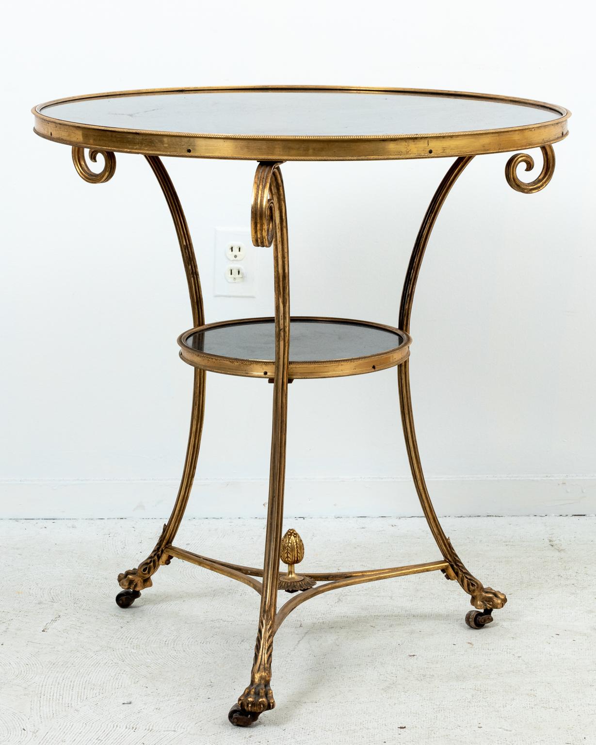 Pair of brass frame and marble top gueridon side tables with lion's paw feet and C-scroll brackets on the base. Please note of wear consistent with age including minor finish loss and patina to the brass.