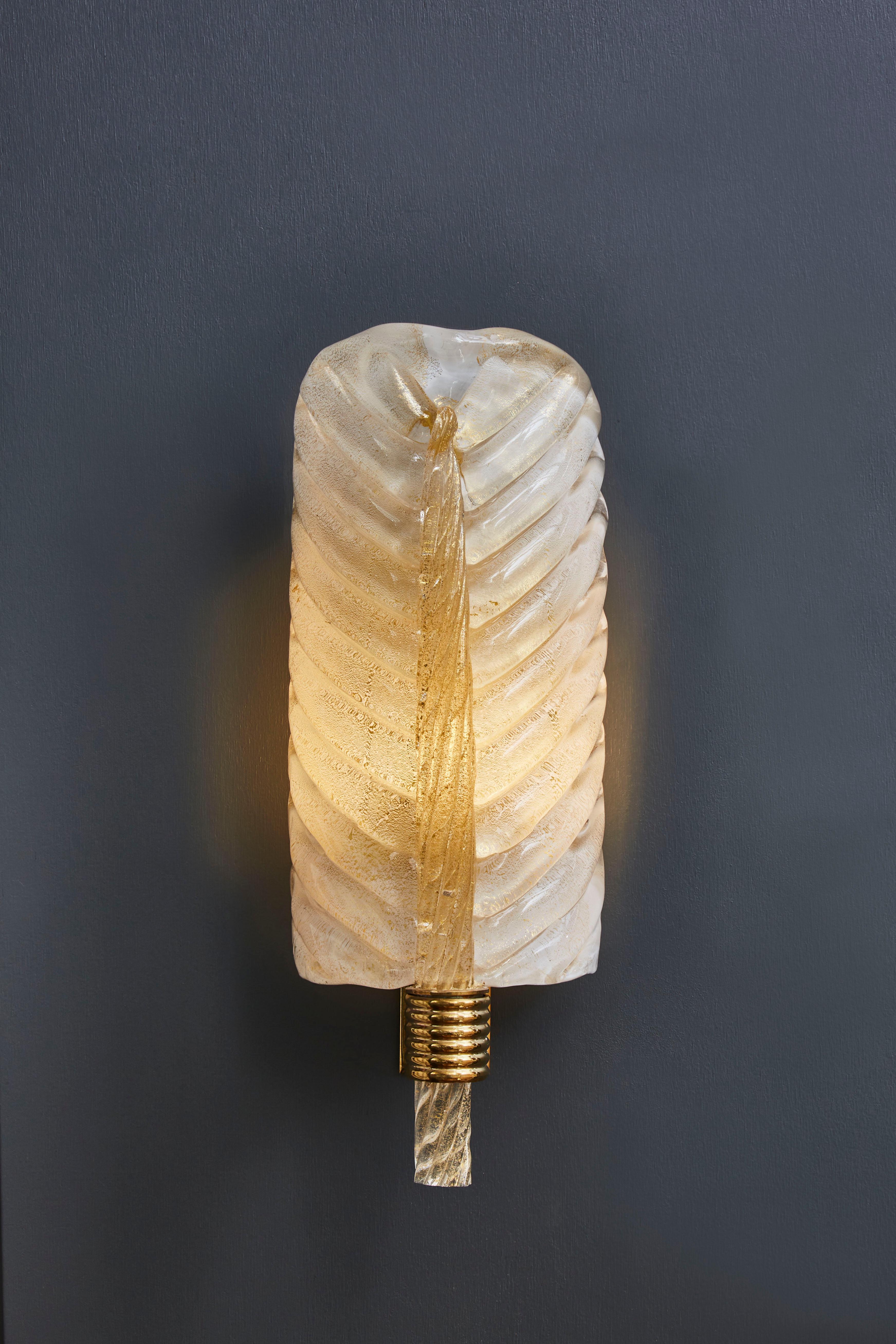 Pair of wall sconces made of brass settings and a beautiful Murano glass leaf letting the light go through.