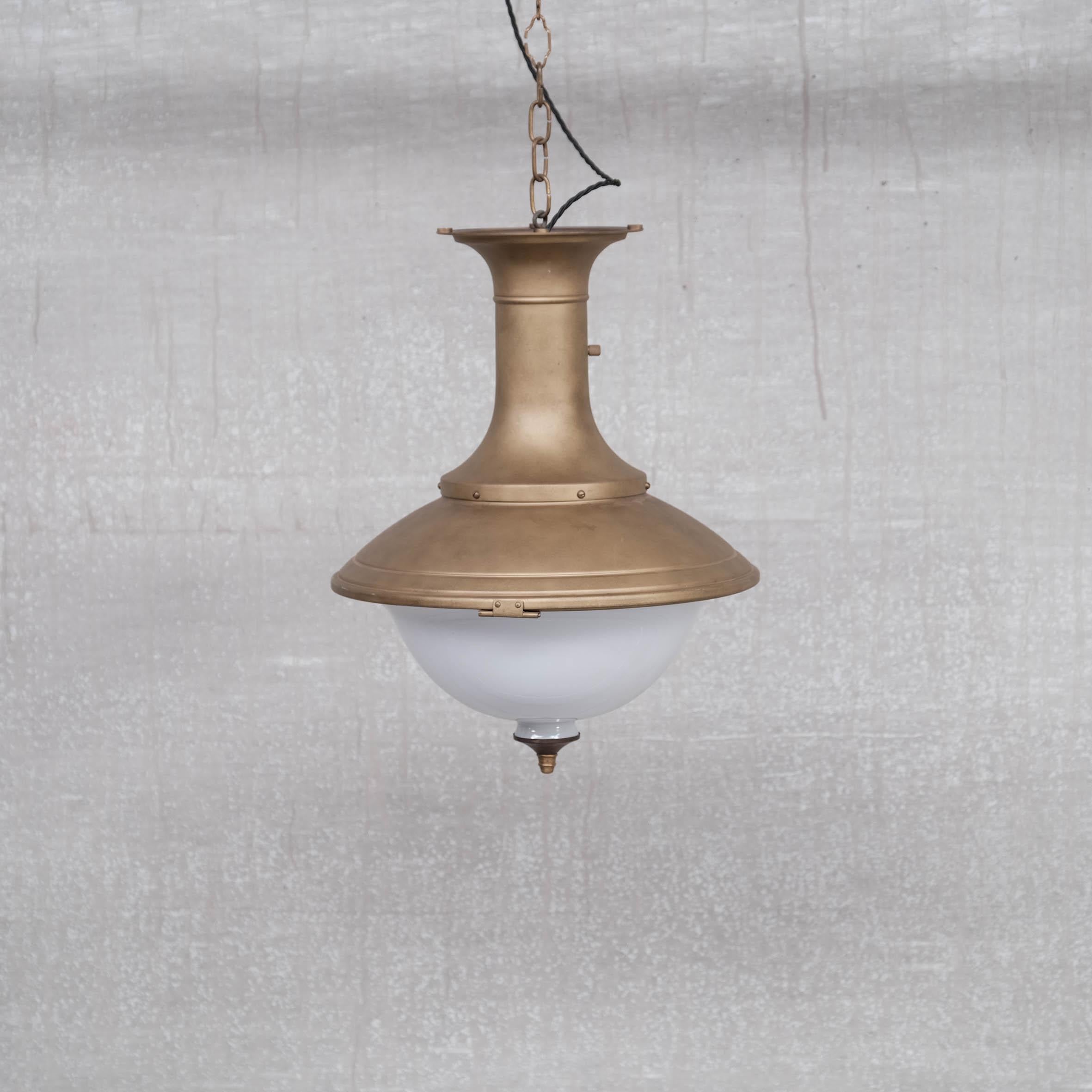 A pair of large brass pendants with opaline glass base, terminating in a brass finial. 

Holland, c1950s.

Heavy and good quality. 

Price is for the pair.

Re-wired and PAT tested. 

No original chain or ceiling rose was retained but