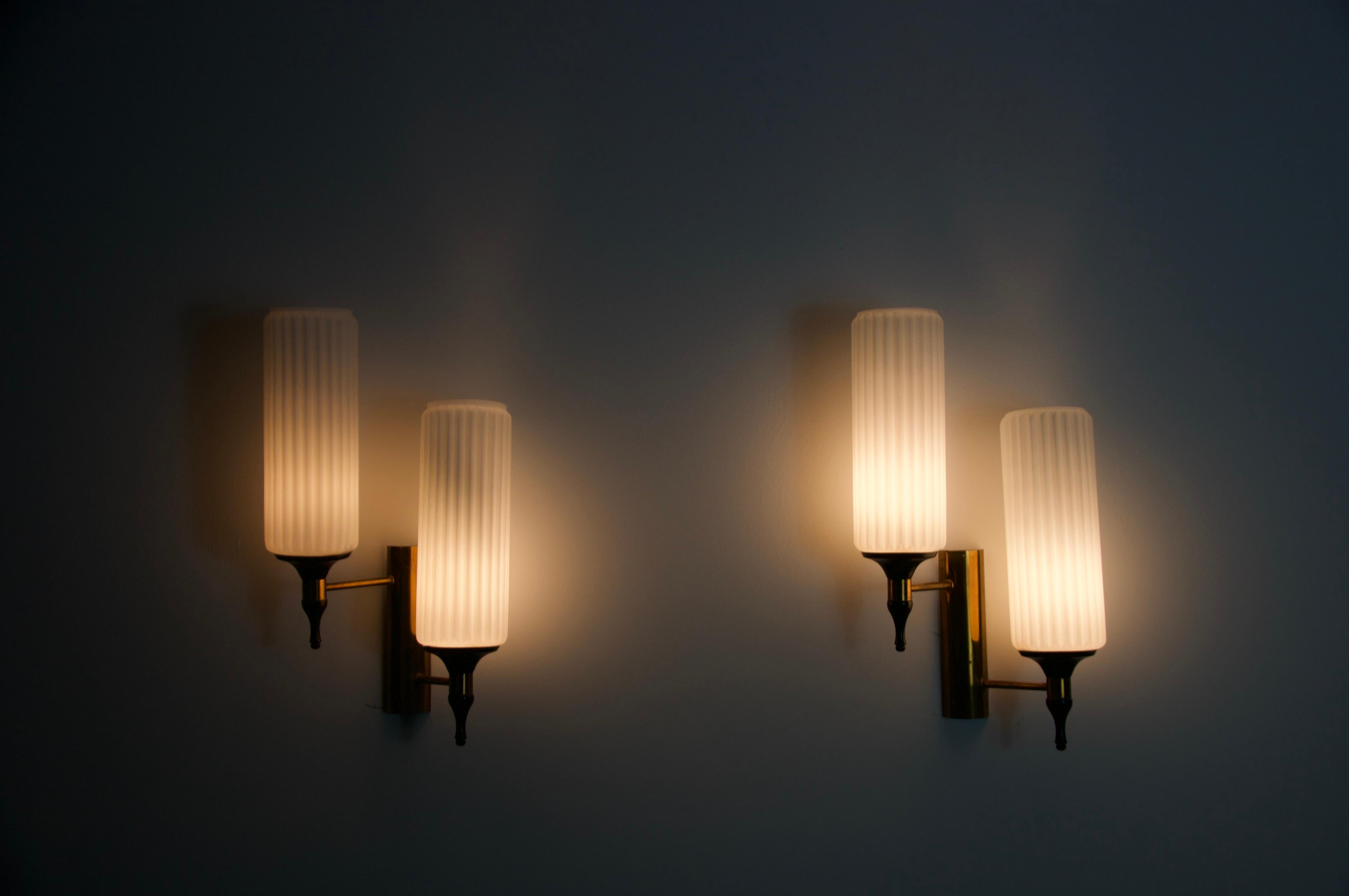 Cette exquise paire d'appliques des années 1960 en provenance d'Italie incarne l'élégance et le savoir-faire du design moderne du milieu du siècle dernier. Conçues et fabriquées par la célèbre marque italienne Stilnovo, ces lampes sont des