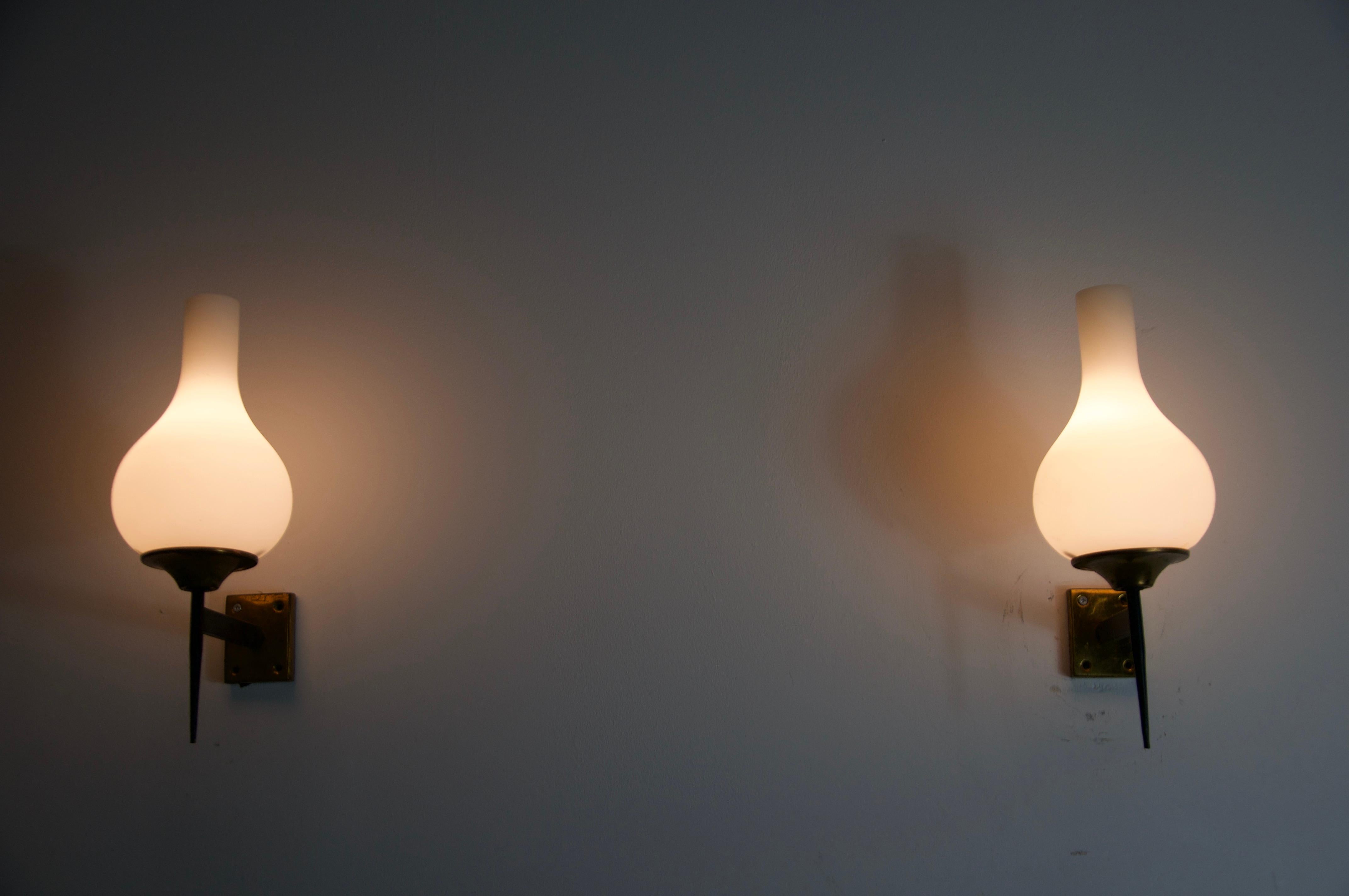 Questa squisita coppia di lampade da parete degli anni '60, proveniente dall'Italia, incarna l'eleganza e la maestria del design moderno della metà del secolo. Progettate e prodotte dal rinomato marchio italiano Stilnovo, queste lampade sono dei