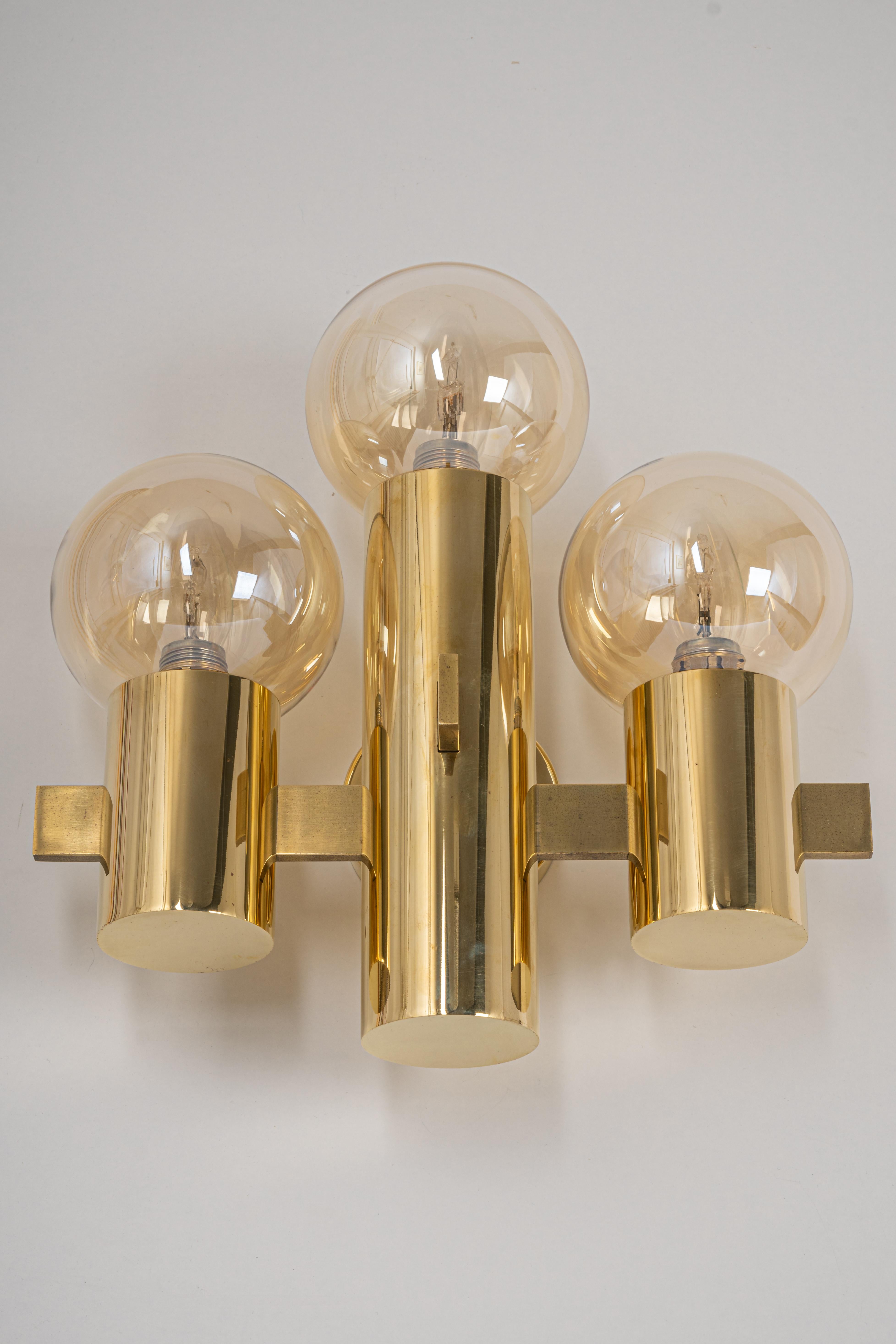 Pair of wall sconces in the manner of Sciolari, Italy, 1960s.
Each sconce is composed of one smoked glass with a brass base.

High quality and in very good condition. Cleaned, well-wired, and ready to use. 
Each sconce requires 3 x E14 standard