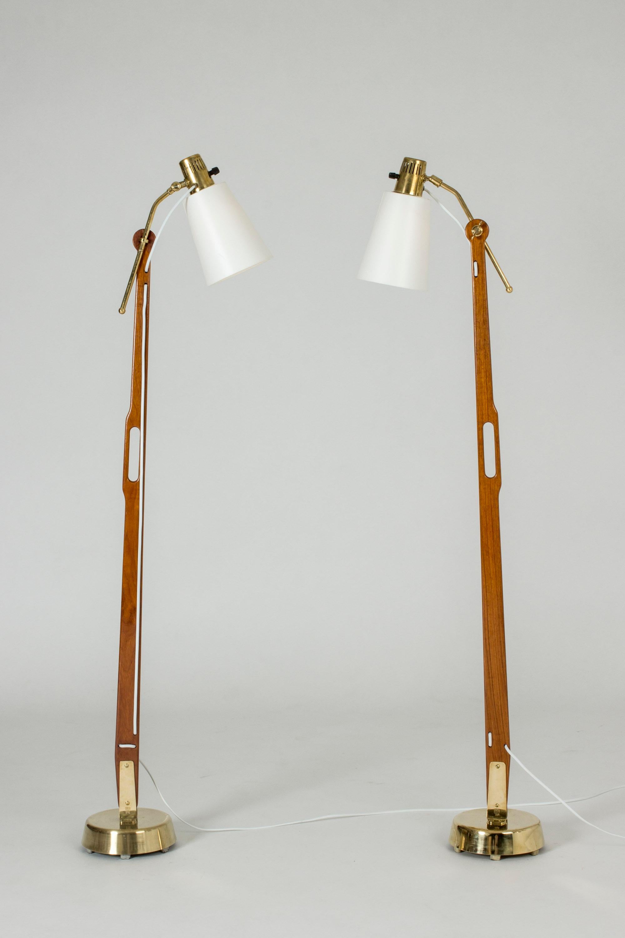 Pair of amazing teak and brass floor lamps by Hans Bergström, with wonderful attention to detail and functionality. The lamp shades can be adjusted in different angles and at different distances from the pole. Handles crafted in the teak, making the