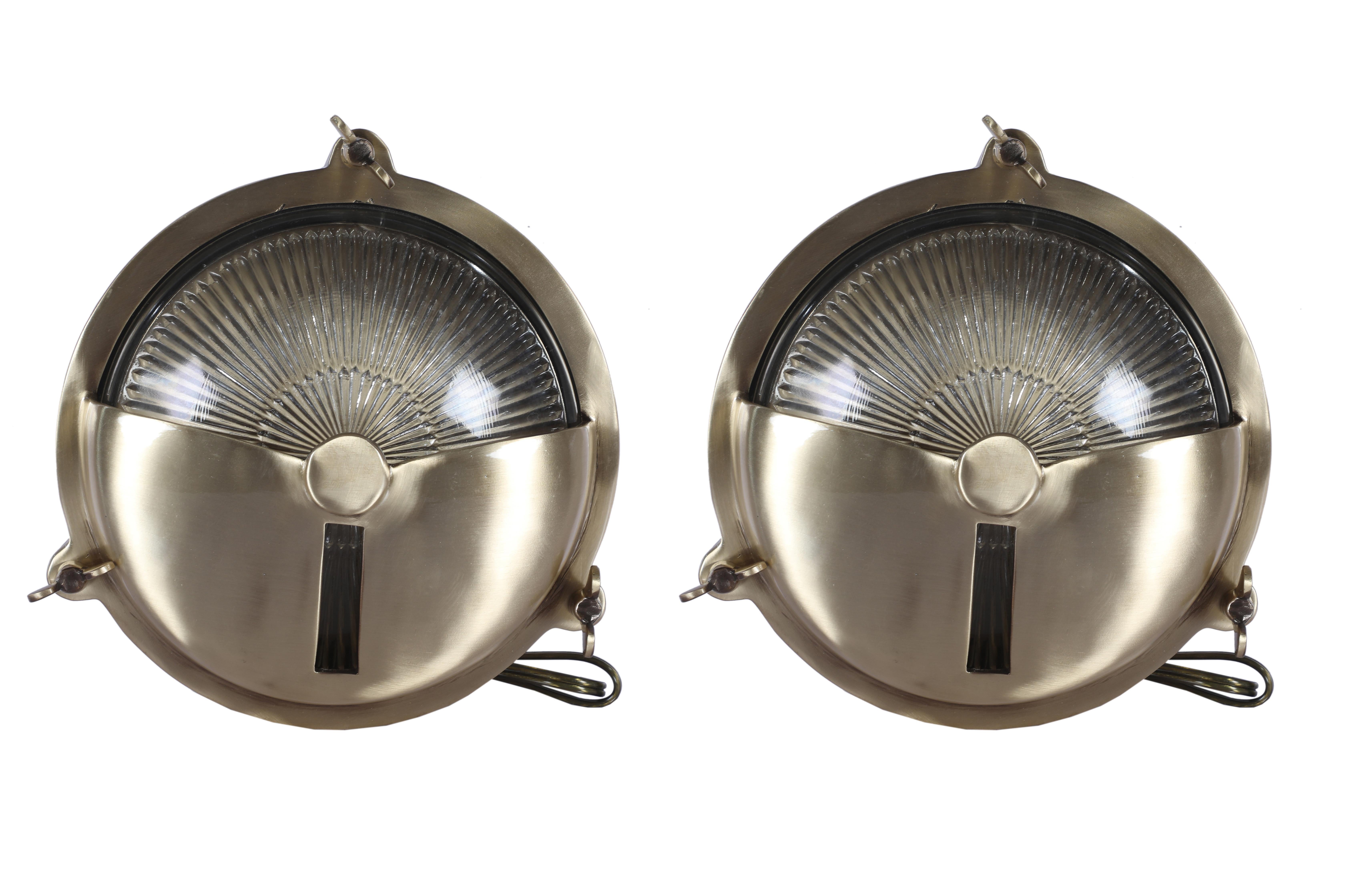 Pair of ship's passageway lights with textured glass shades and lacquered brass shades and brass backs.  Required for American use and takes a standard base light bulb.  Brackets for easy mounting and wing nuts for easy access to change the bulb. 