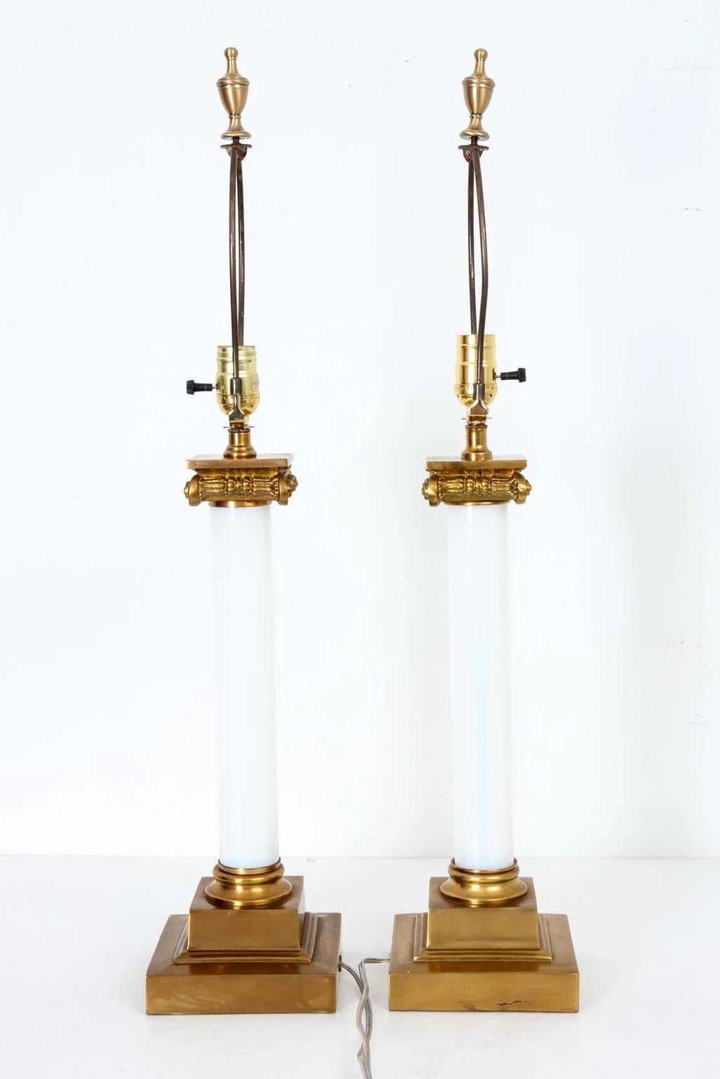 Coppia di eleganti lampade in vetro a colonna in stile neoclassico Paul Hanson degli anni '50-'60. Ogni lampada è caratterizzata da una colonna in vetro incamiciato con capitello e base in ottone. Ottima qualità. Ricablata di recente. Conserva la
