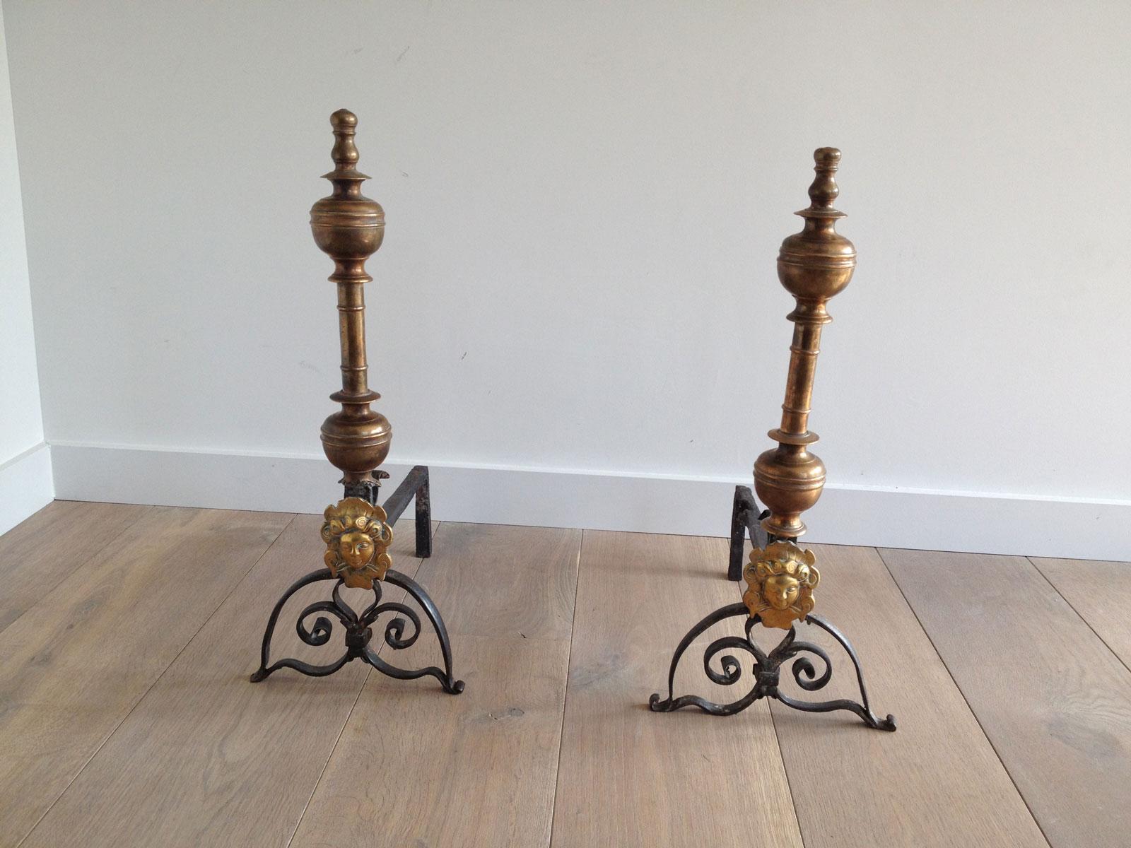 This pair of andirons made of brass and wrought iron shows the 