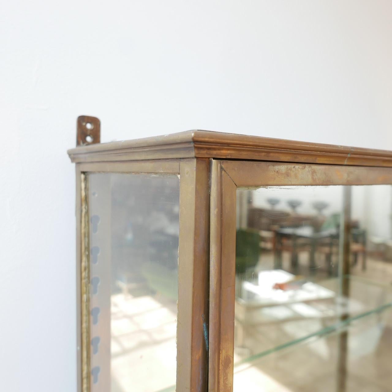 A pair of antique vitrines.

France, early 20th century.

Brass, glass and oak bases.

The bases can be removed.

The shelves are adjustable.

Mirrored back and base.

Price is for the pair. 

Dimensions: 76.5 W x 160.5 H x 20.5 D for