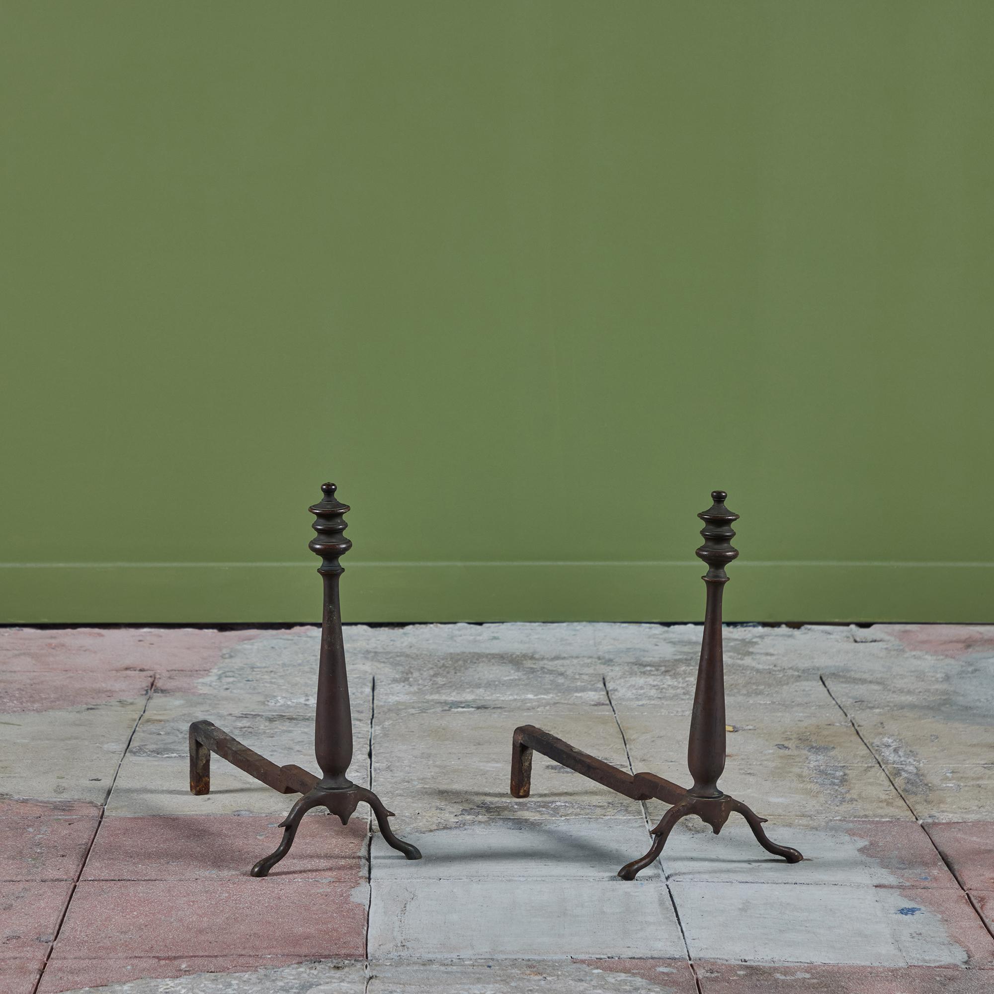 Pair of brass andirons featuring spindle feet and a tapered shaft with a layered three disc finial atop each. 

Dimensions
8