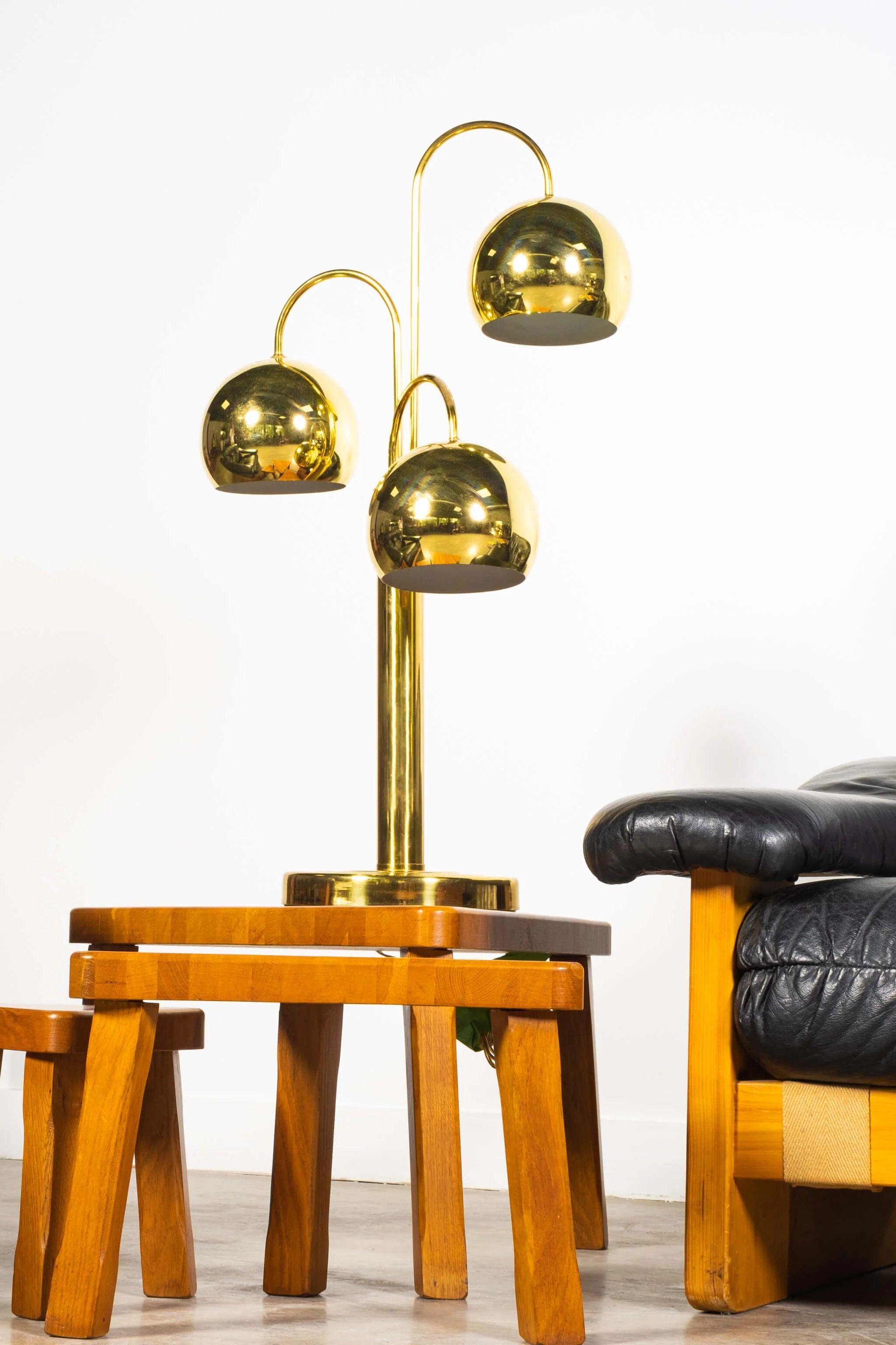 Pair of tall brass “eyeball” table lamps by Robert Sonneman. Among Sonneman’s hallmark 1970s waterfall design, his work features unconventional treatments toward shape and balance, often inspired by modern architecture. The designer once said of his