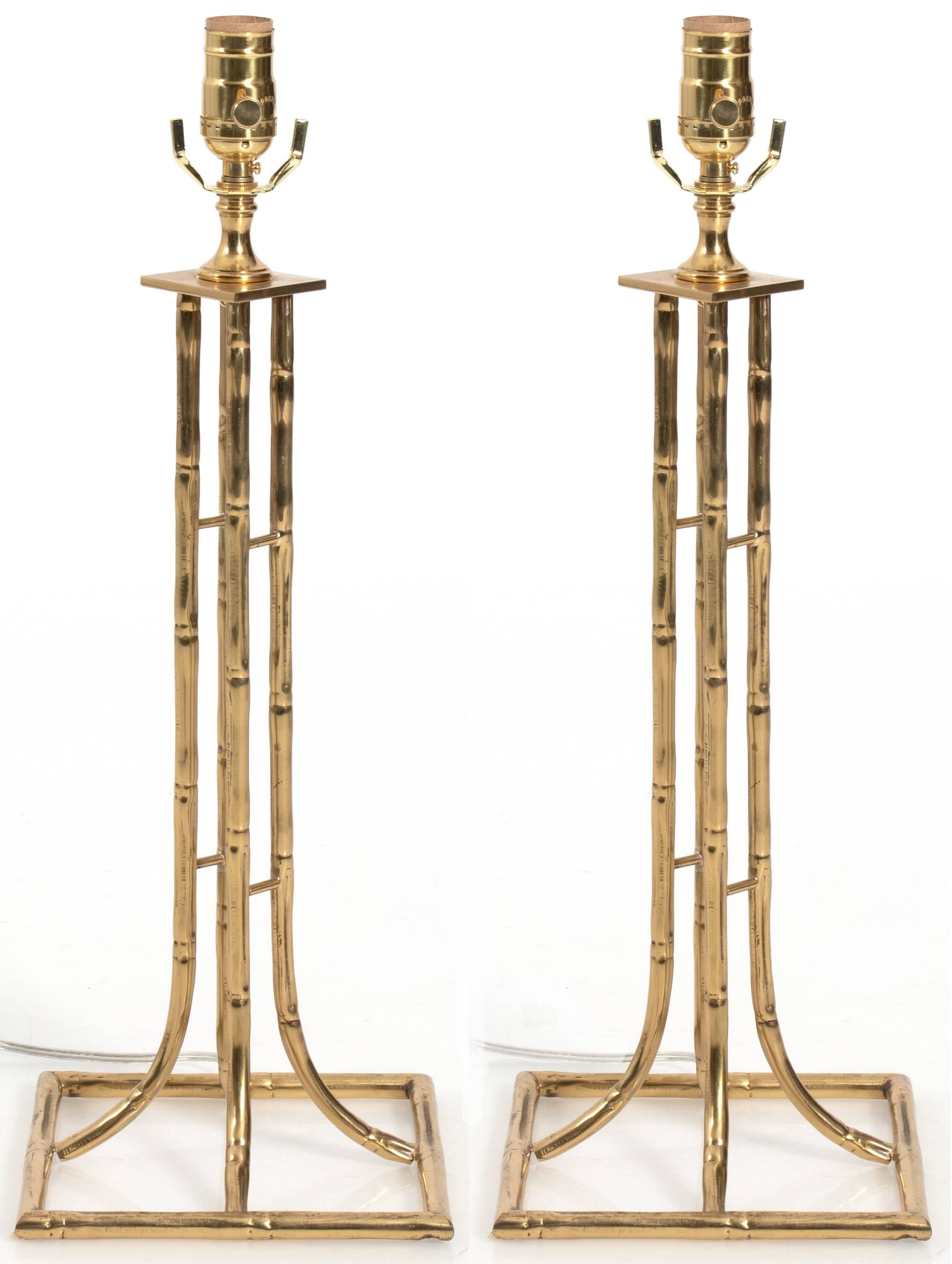 Pair of brass bamboo style lamps by Maison Baguès. Newly rewired. Each lamp takes one standard bulb. Black oval paper lampshades with gold lining included. Measurements are without shade/harps.