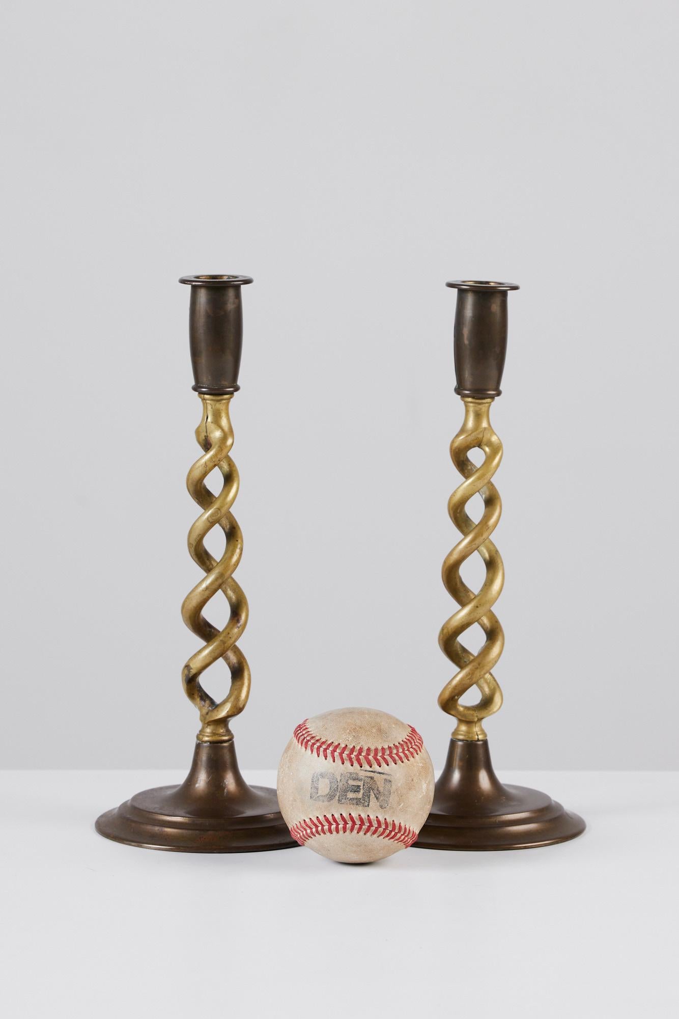 Pair of solid brass candlesticks, by Peerage, c.1920s, England. The pair of beautifully patinated candlesticks feature barley twist stems, round tiered bases.

Marked - Peerage England on the underside

Dimensions: 4” diameter x 10” height; stem