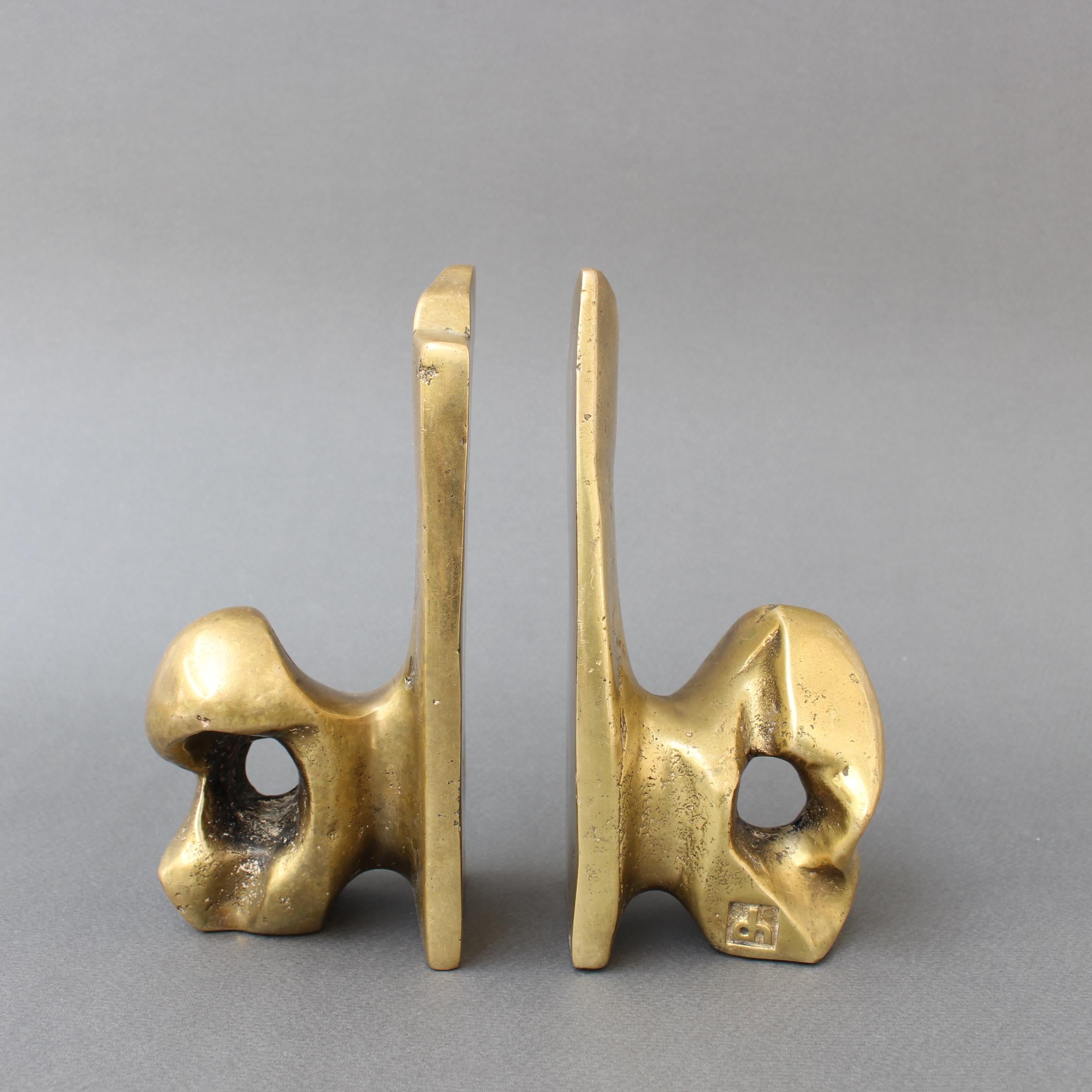 Pair of brass bookends by David Marshall (circa 1980s). These are weighty, cratered and raw as if plucked right from nature yet sculptural at the same time - works of art in their own right. In good overall condition. The David Marshall trademarks /