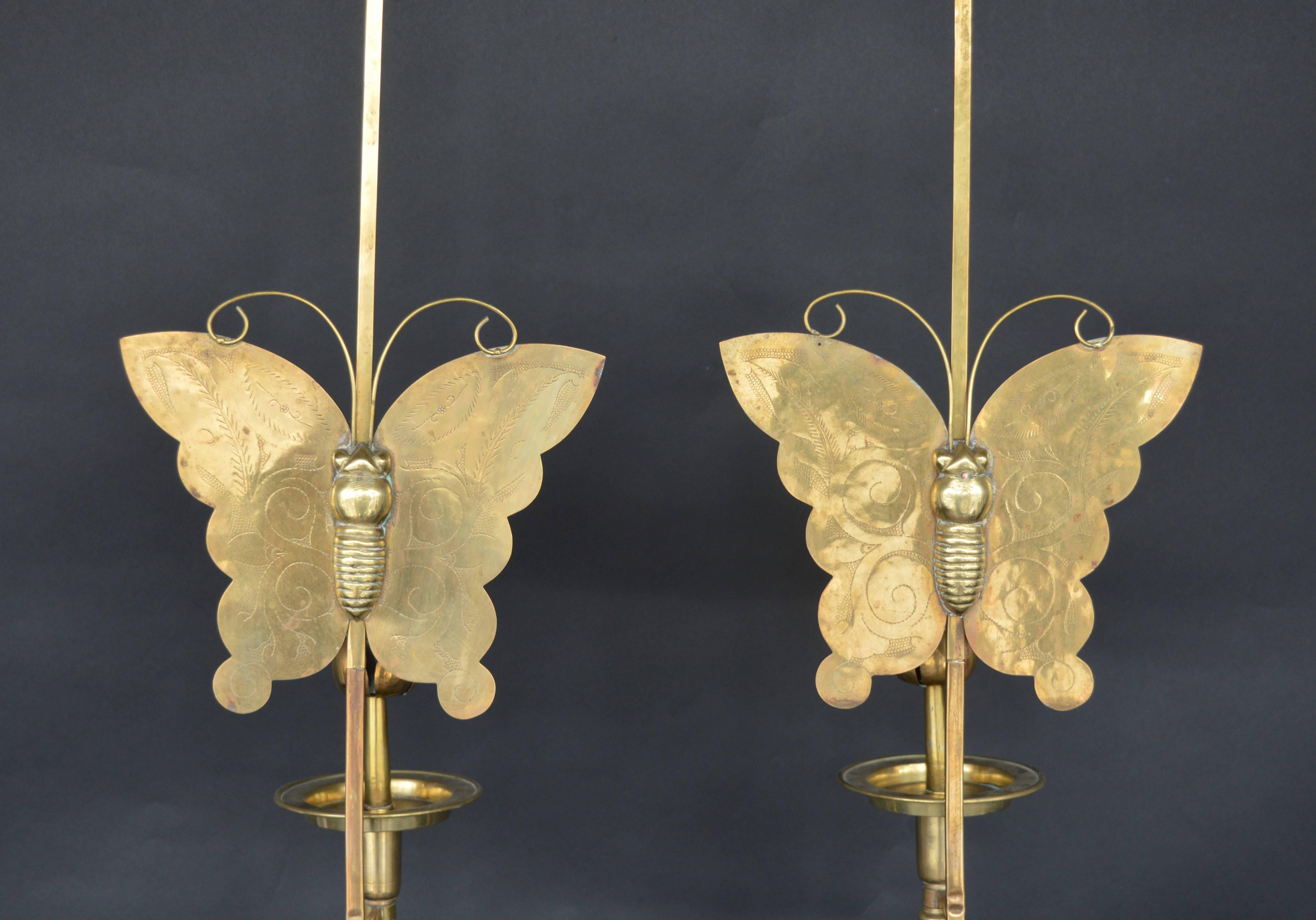 Pair of brass butterfly candlesticks.