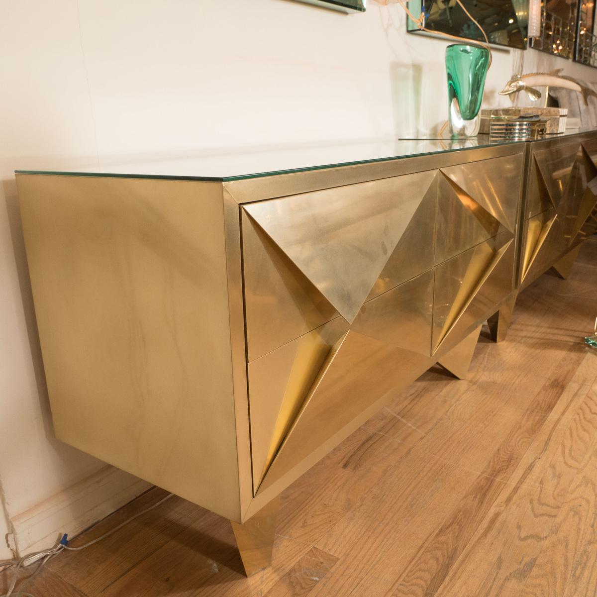Pair of brass cabinets with diamond form front details and pyramidal legs.