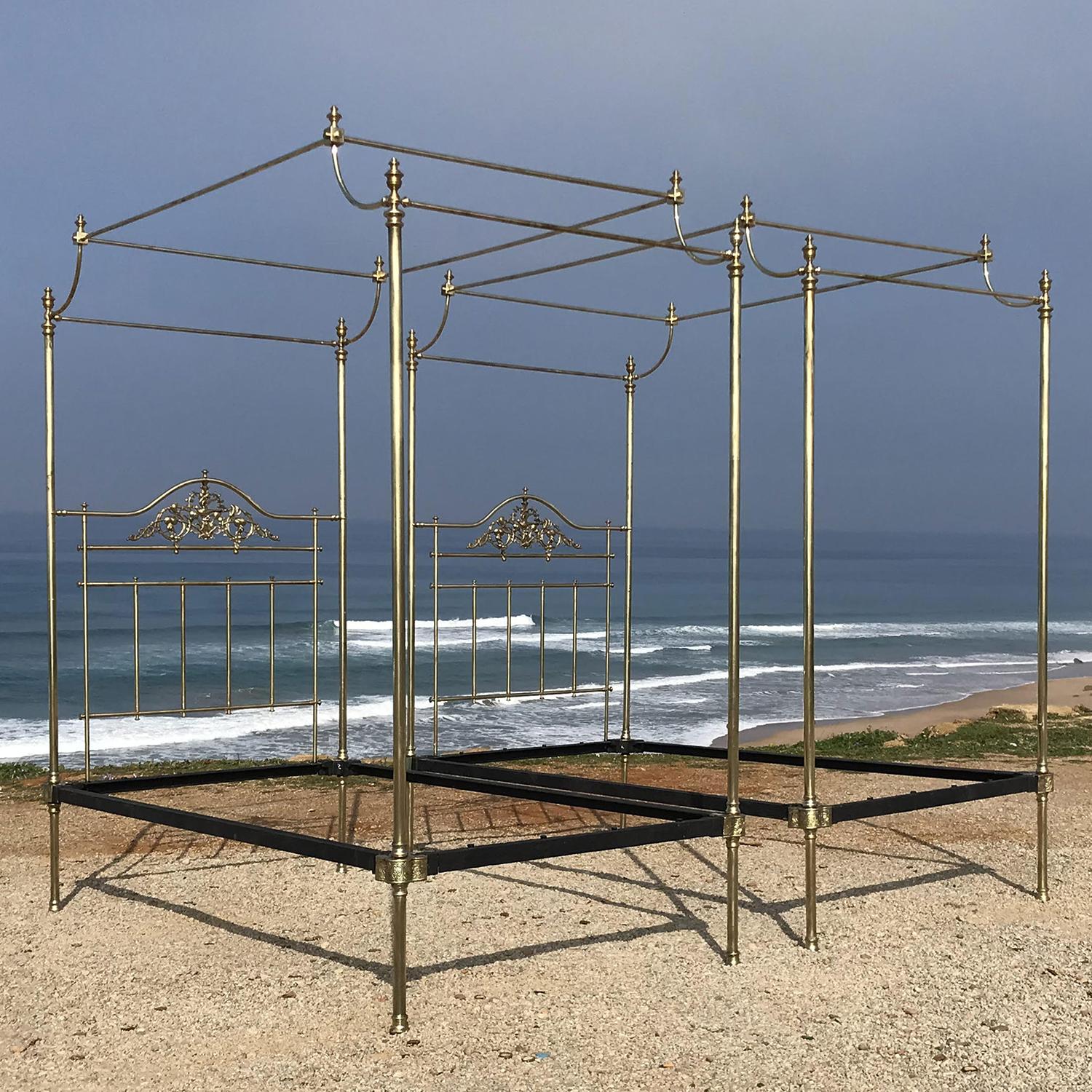 A magnificent pair of all brass four poster beds with delicate posts, ornate brass casting in the head panels below serpentine rails, decorative brass knee-caps and arched canopies.

These superb four poster beds were originally manufactured in