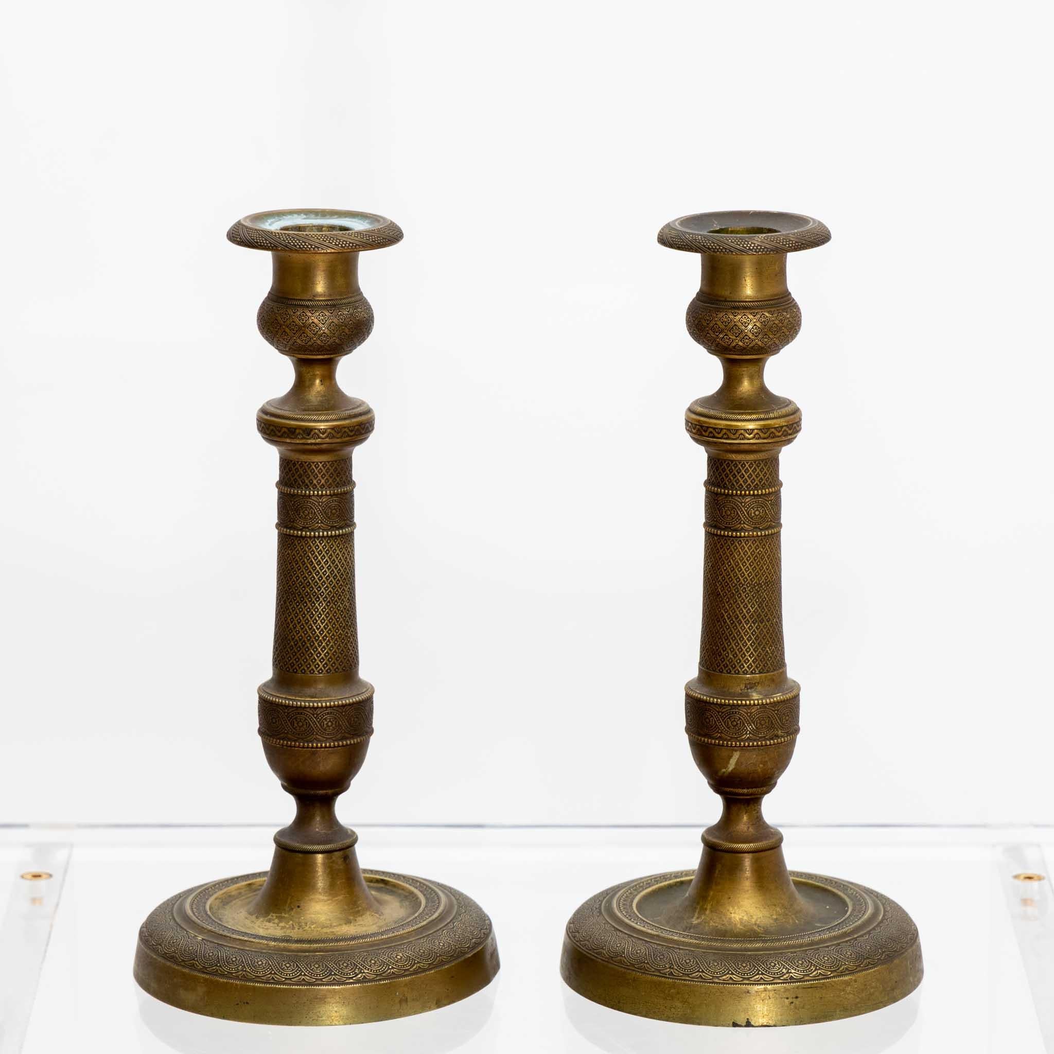 Pair of brass candlesticks with round base and baluster shaped stem.
