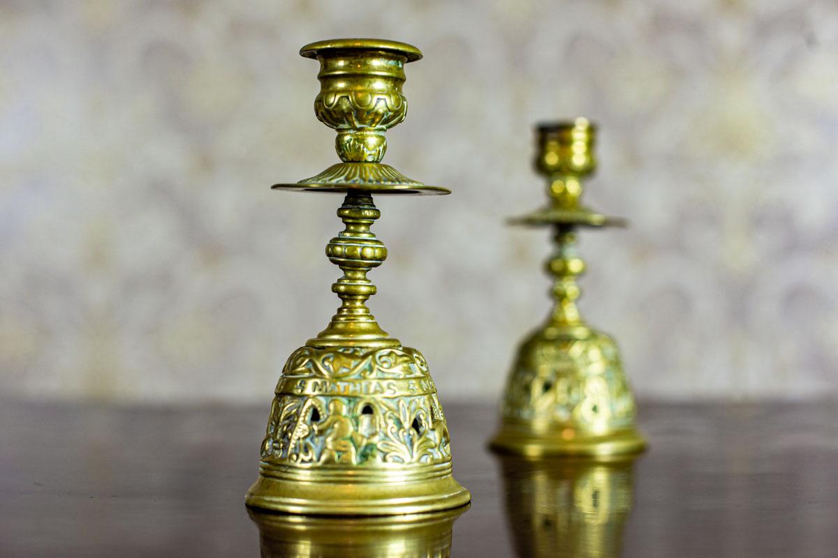We present you two small brass candlesticks.
These items are from before the year 1939.
The base is in the shape of a bell, covered with an openwork pattern and names of four apostles.

The candlesticks are in very good condition.
